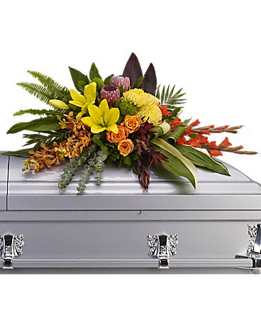 Colorful floral spray arranged on a silver casket