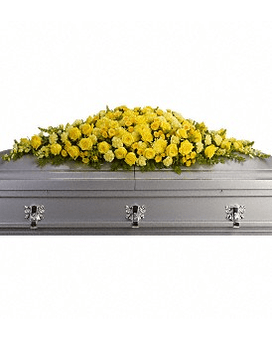 Yellow floral casket spray on a gray casket