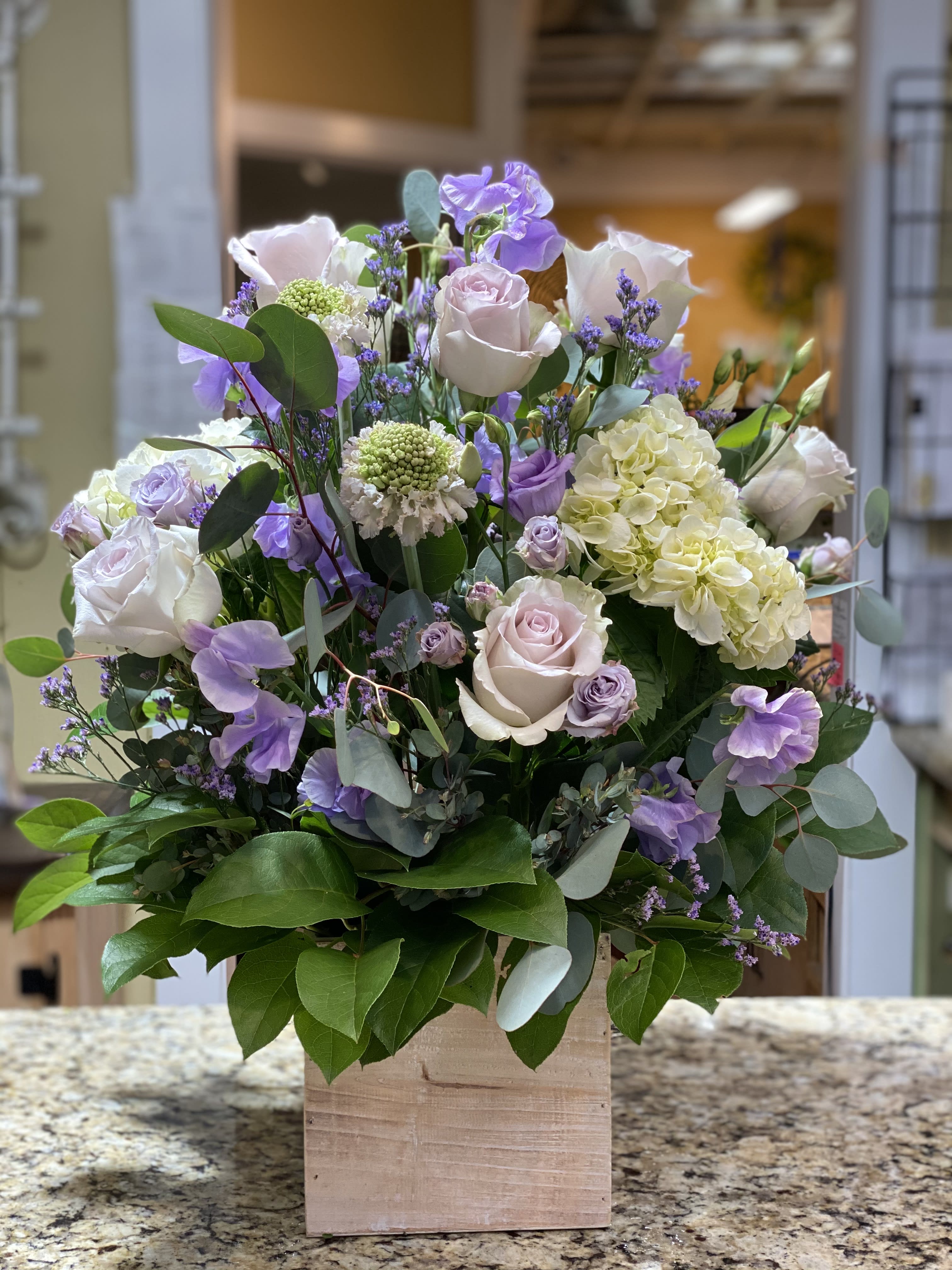 Lavender and white rose arrangement in a wooden box