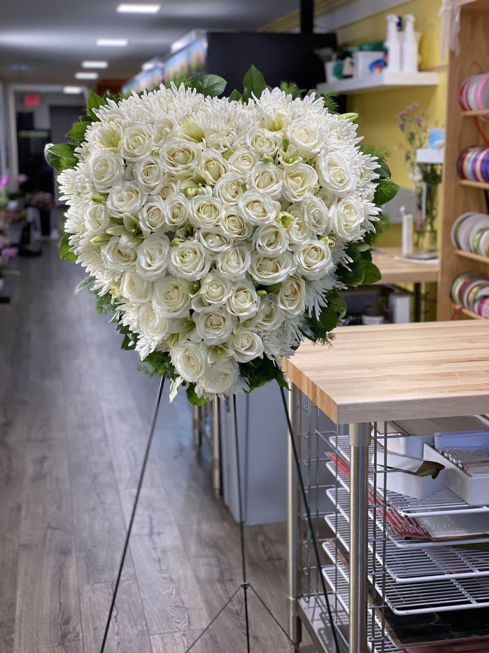 Large white rose and chrysanthemum standing spray on an easel