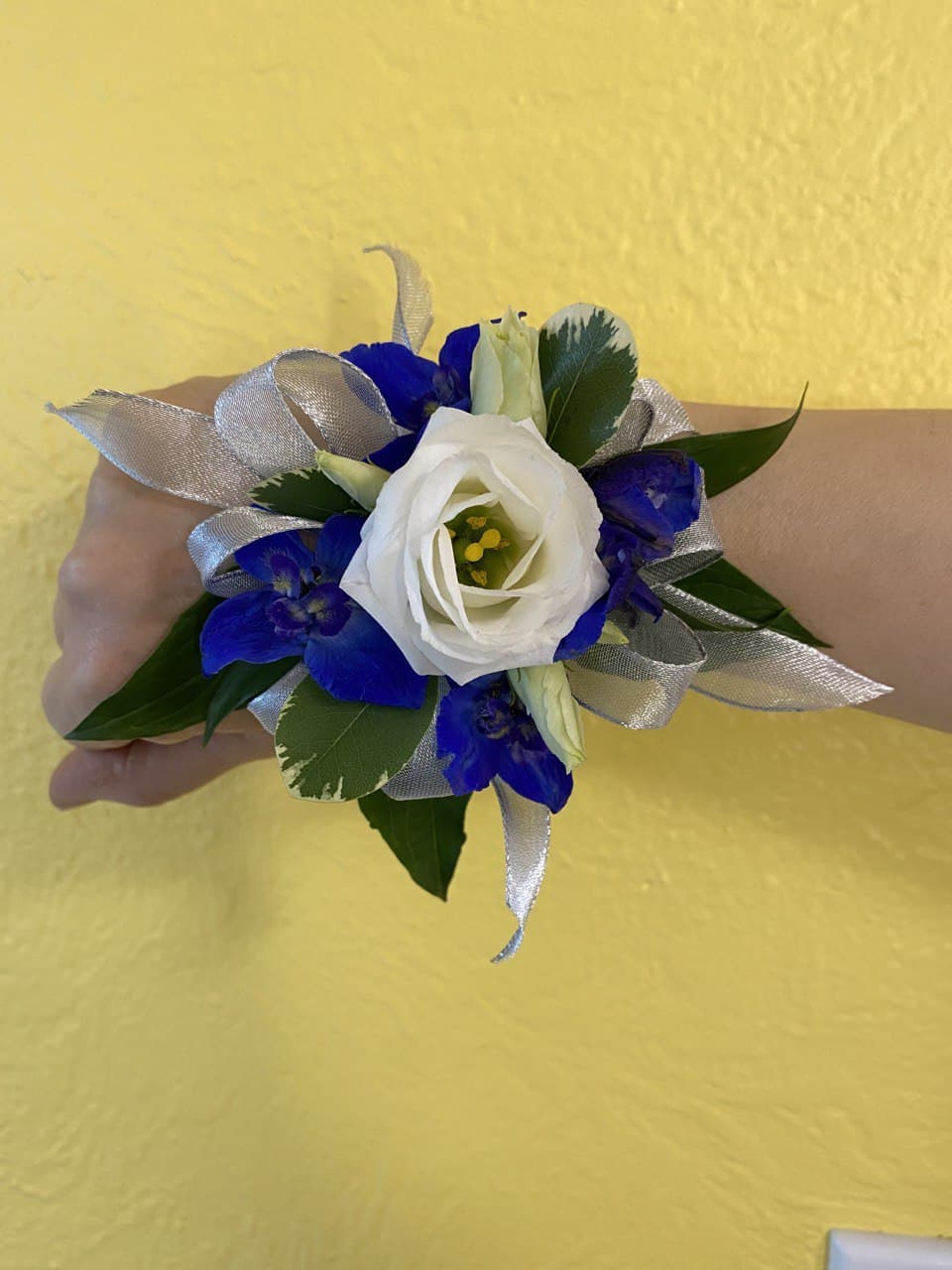 White and blue wrist corsage with silver ribbon