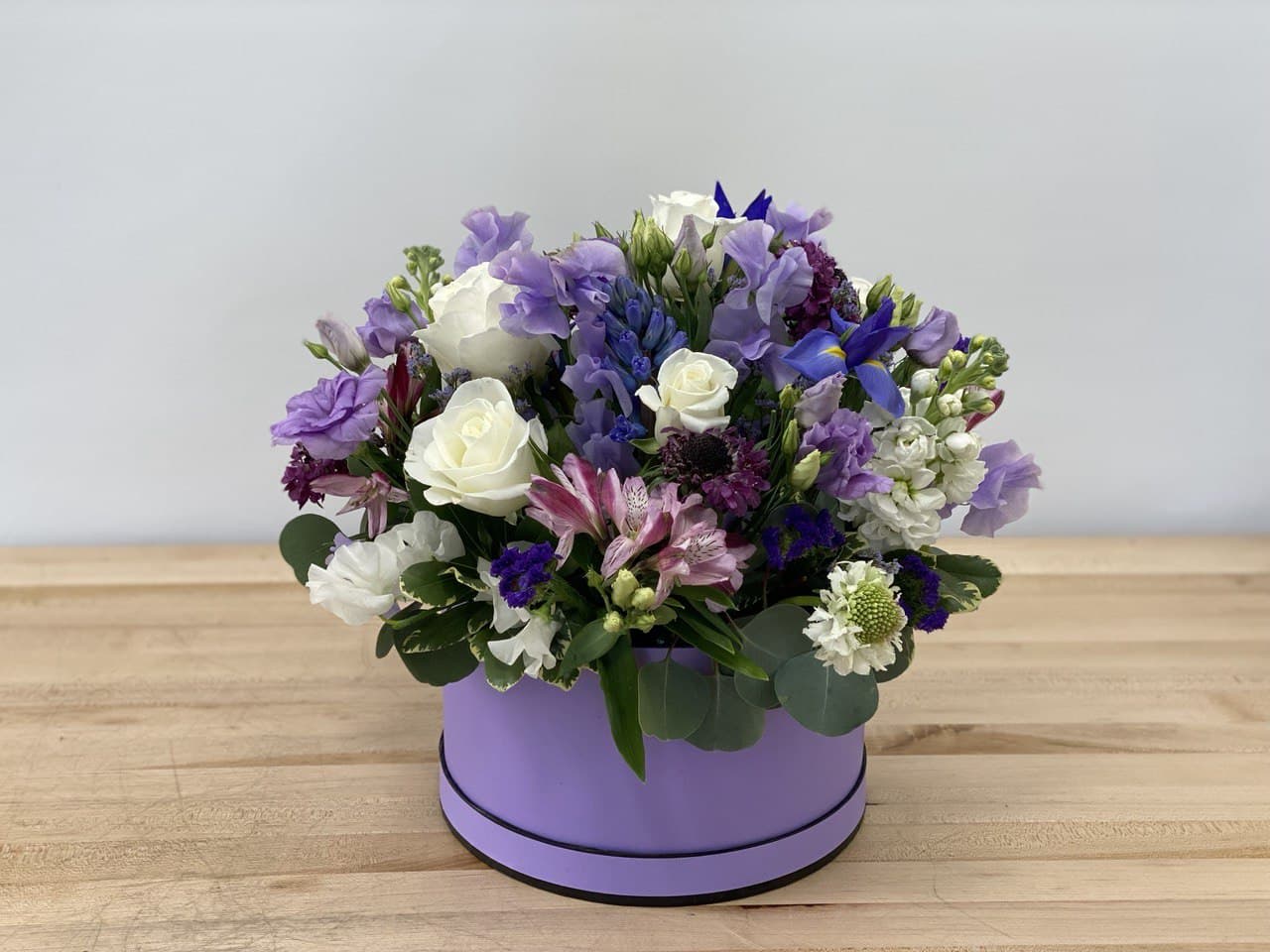 Purple and white mixed flower arrangement in a lavender box