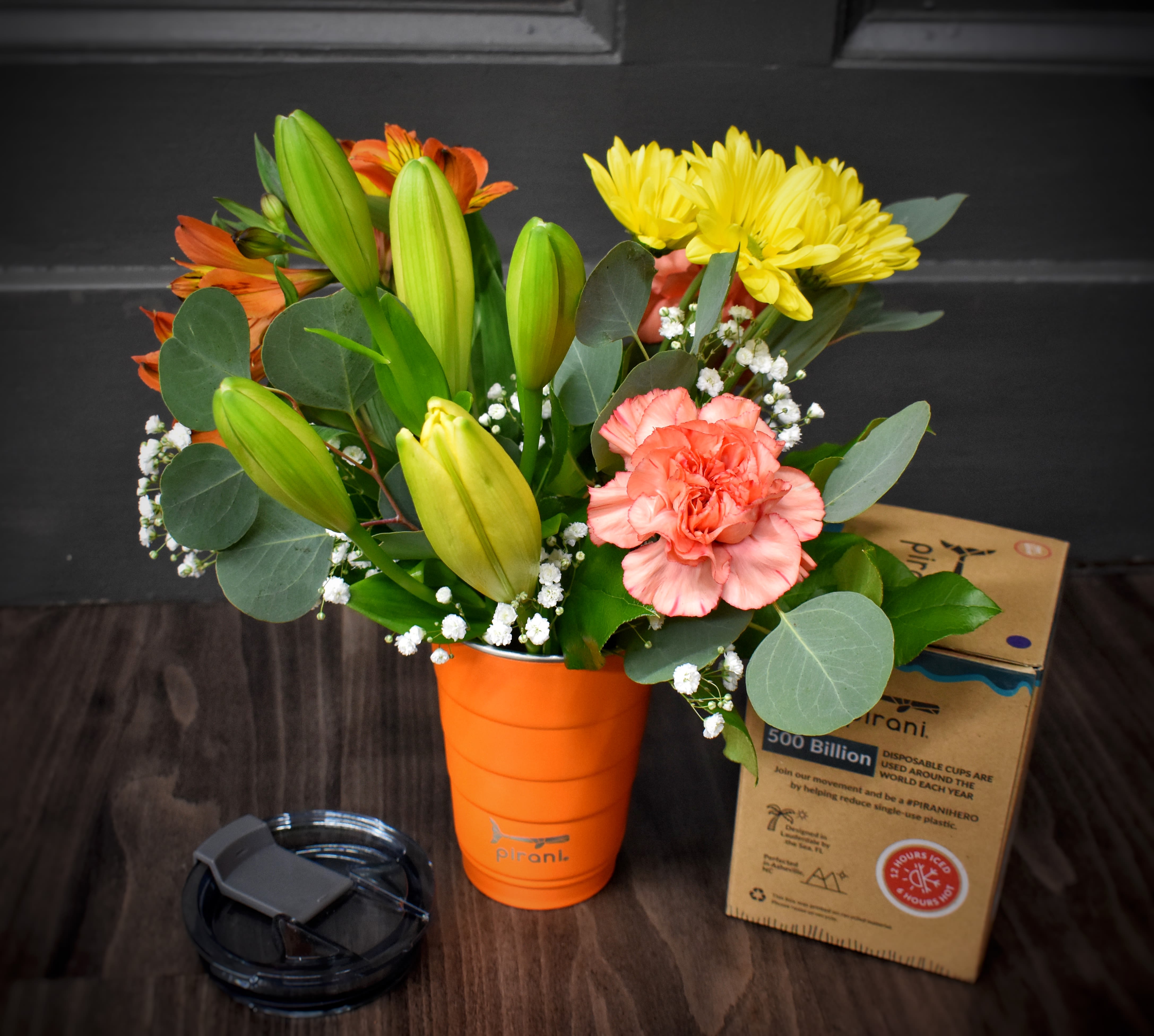 Sippy Stems in Orange - The perfect gift, A Pirani brand insulated party tumbler in orange, filled with fresh cut orange and yellow flowers. This insulated cup can have hot or cold beverages and is dishwasher safe. #partysustainably