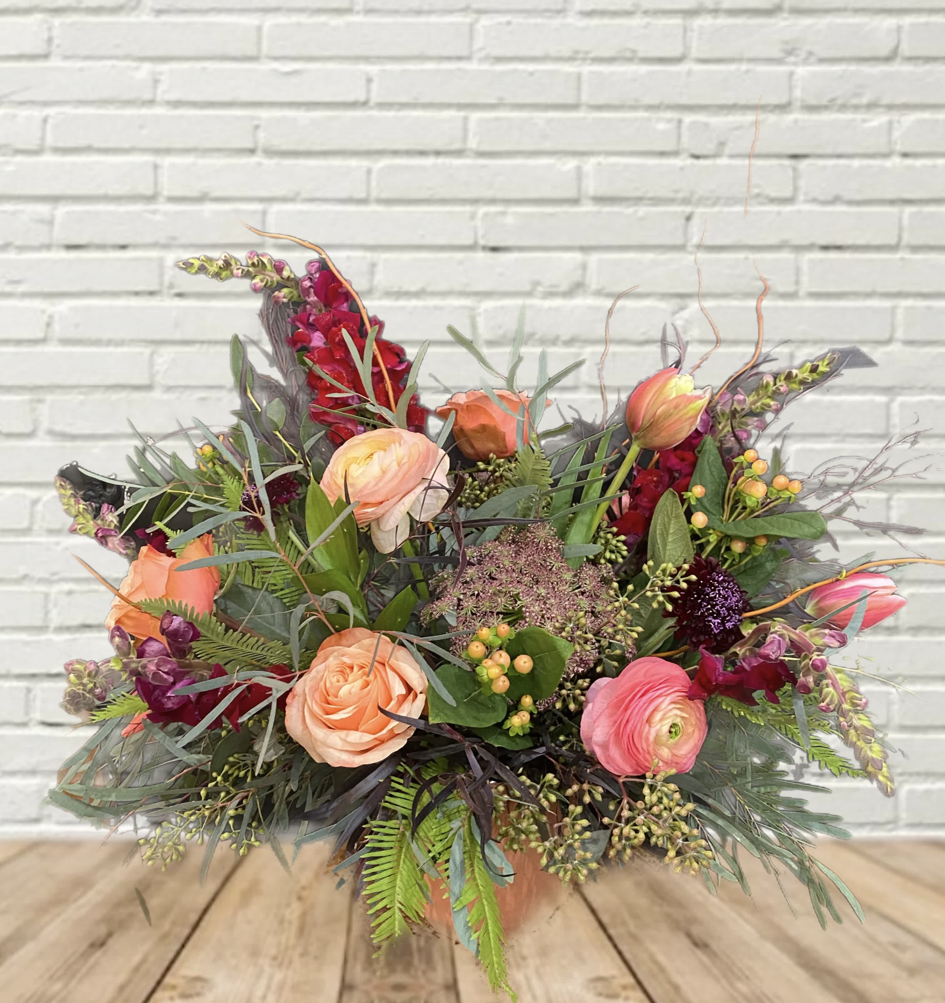 Mixed bouquet of peach and pink flowers in a vase
