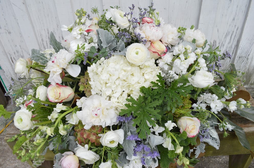 Large white floral arrangement with pale pink roses and purple accents