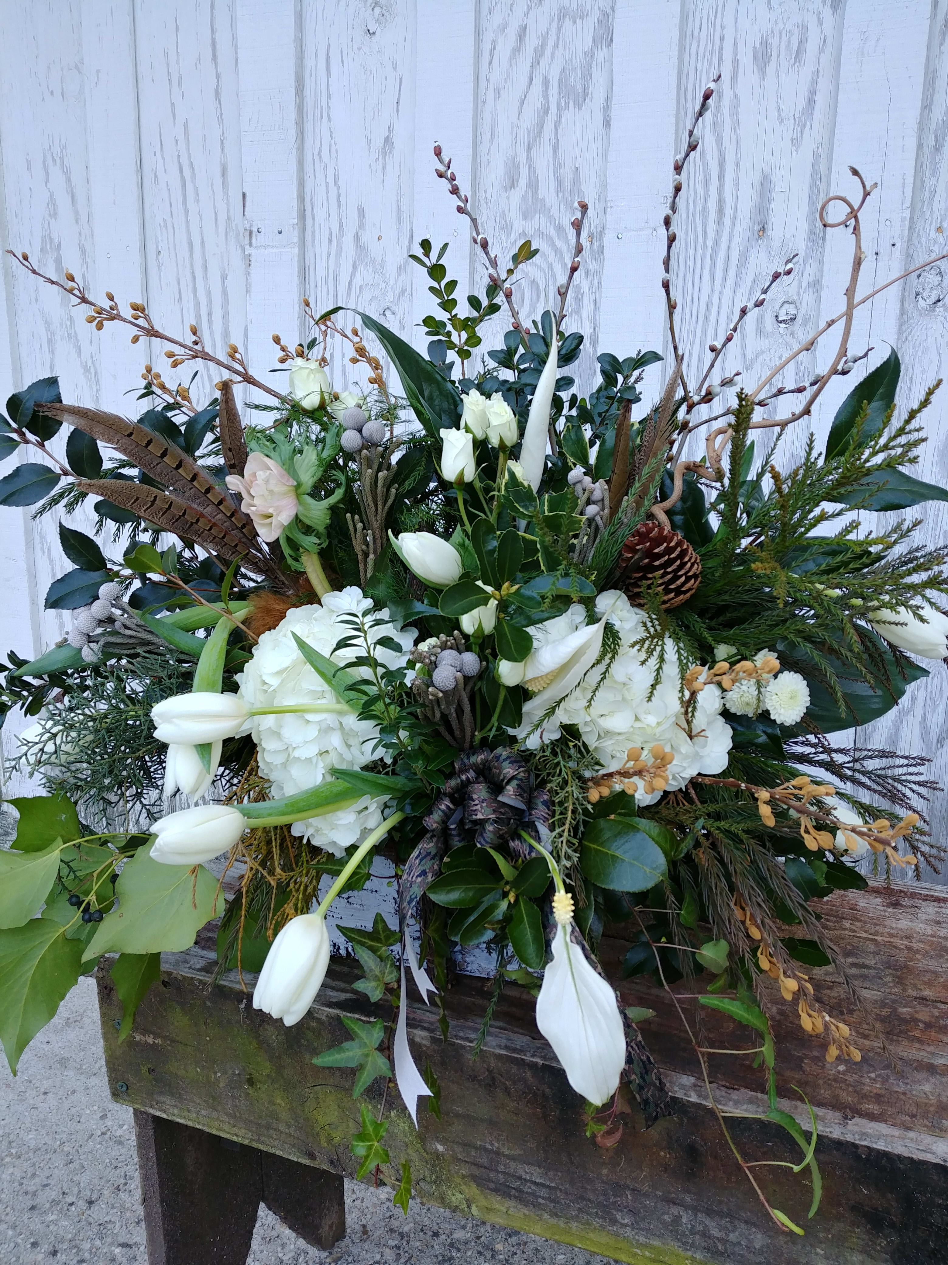 Large white floral arrangement with tulips, hydrangeas, and branches