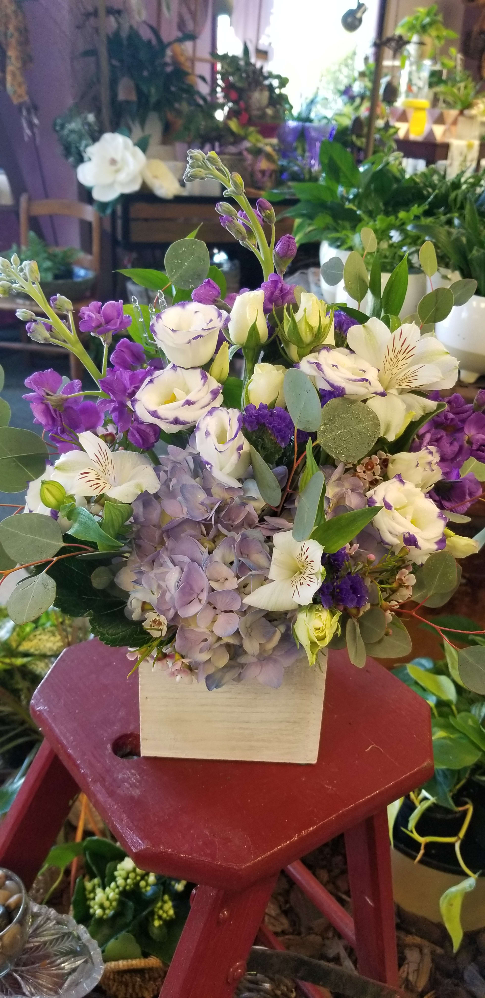 Purple and white bouquet in a square wooden box