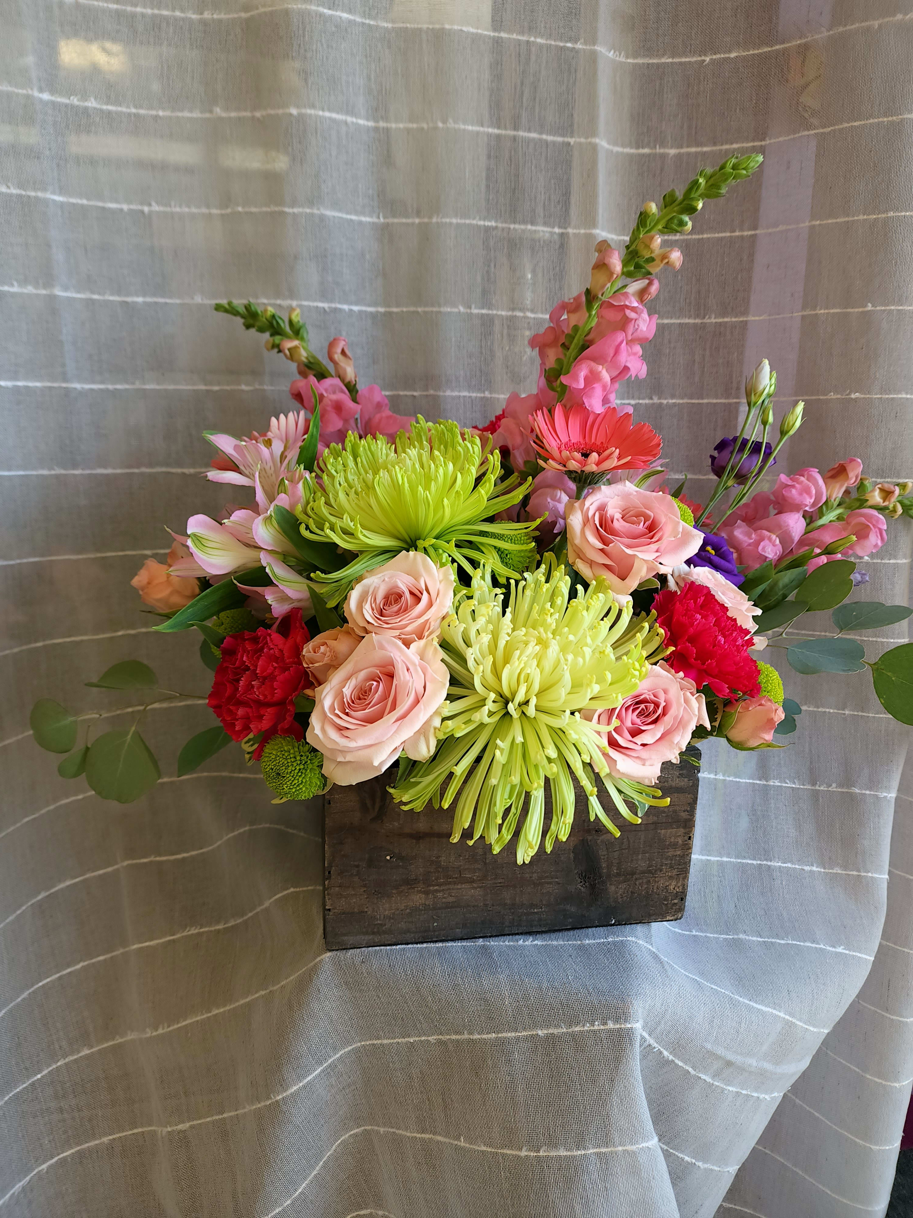 Mixed bouquet in a wooden box with pink roses and bright green chrysanthemums