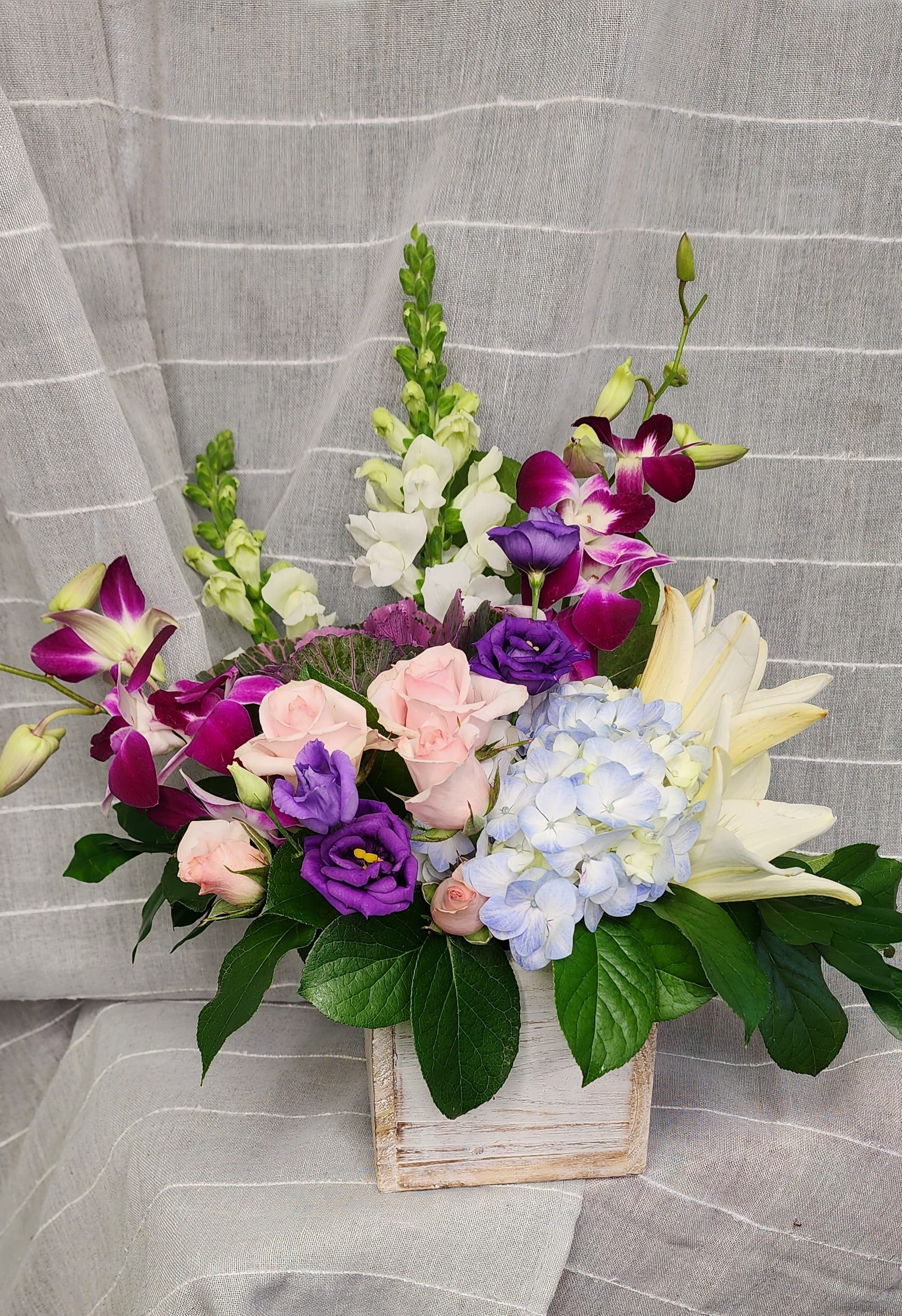 Island Love by MG Florist  - A beautiful array of dendrobium orchids, lilies, spray roses,  lisianthus, snapdragons, and hydrangea designed in a glass cube. Colors may vary.