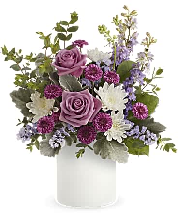 Teleflora's Playfully Yours Bouquet - A playful spin on the classic rose bouquet, these lovely lavender blooms look fun and flirty in this frosted white glass jar. Lavender roses, purple button spray chrysanthemums, white cushion spray chrysanthemums, lavender larkspur and lavender sinuata statice are arranged with dusty miller, parvifolia eucalyptus and lemon leaf. Delivered in Teleflora's Savannah Jar. Orientation: All-Around