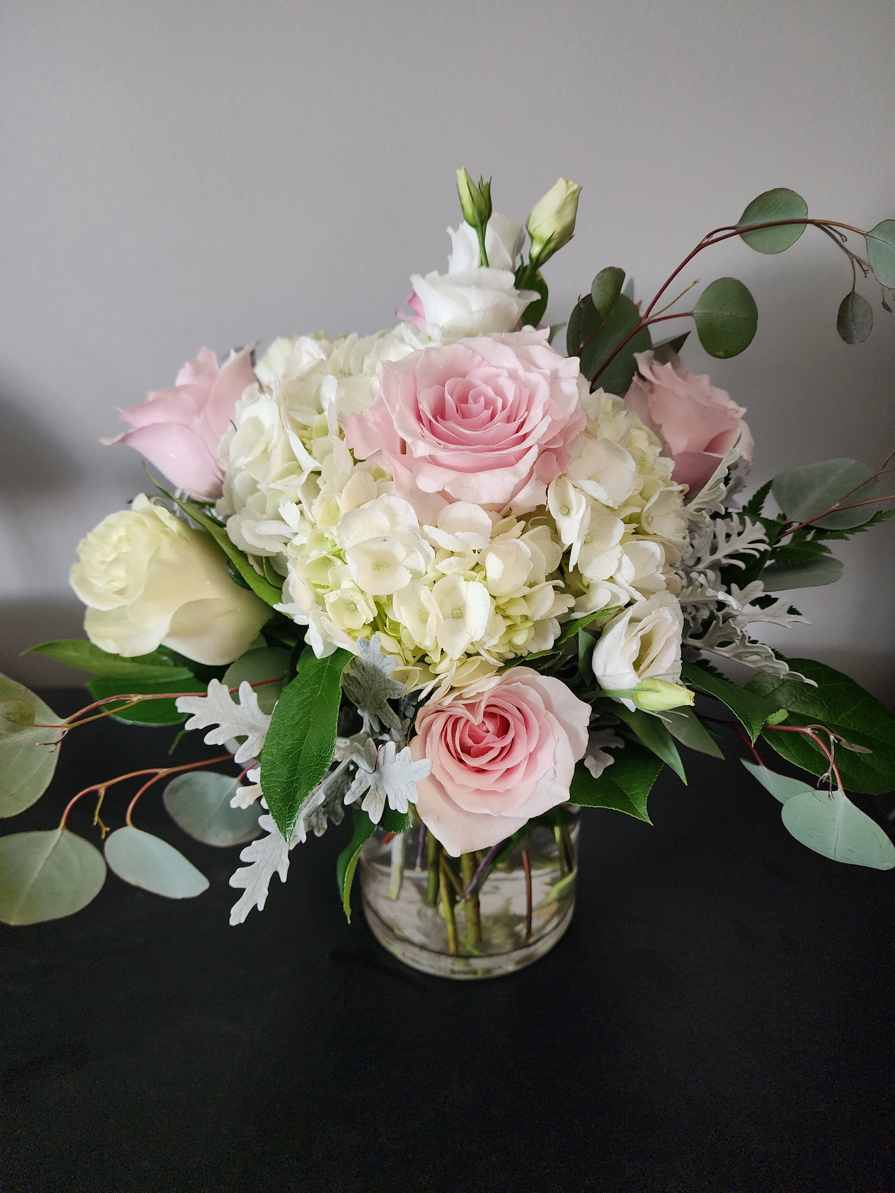 Pink and white roses with hydrangeas in a glass vase