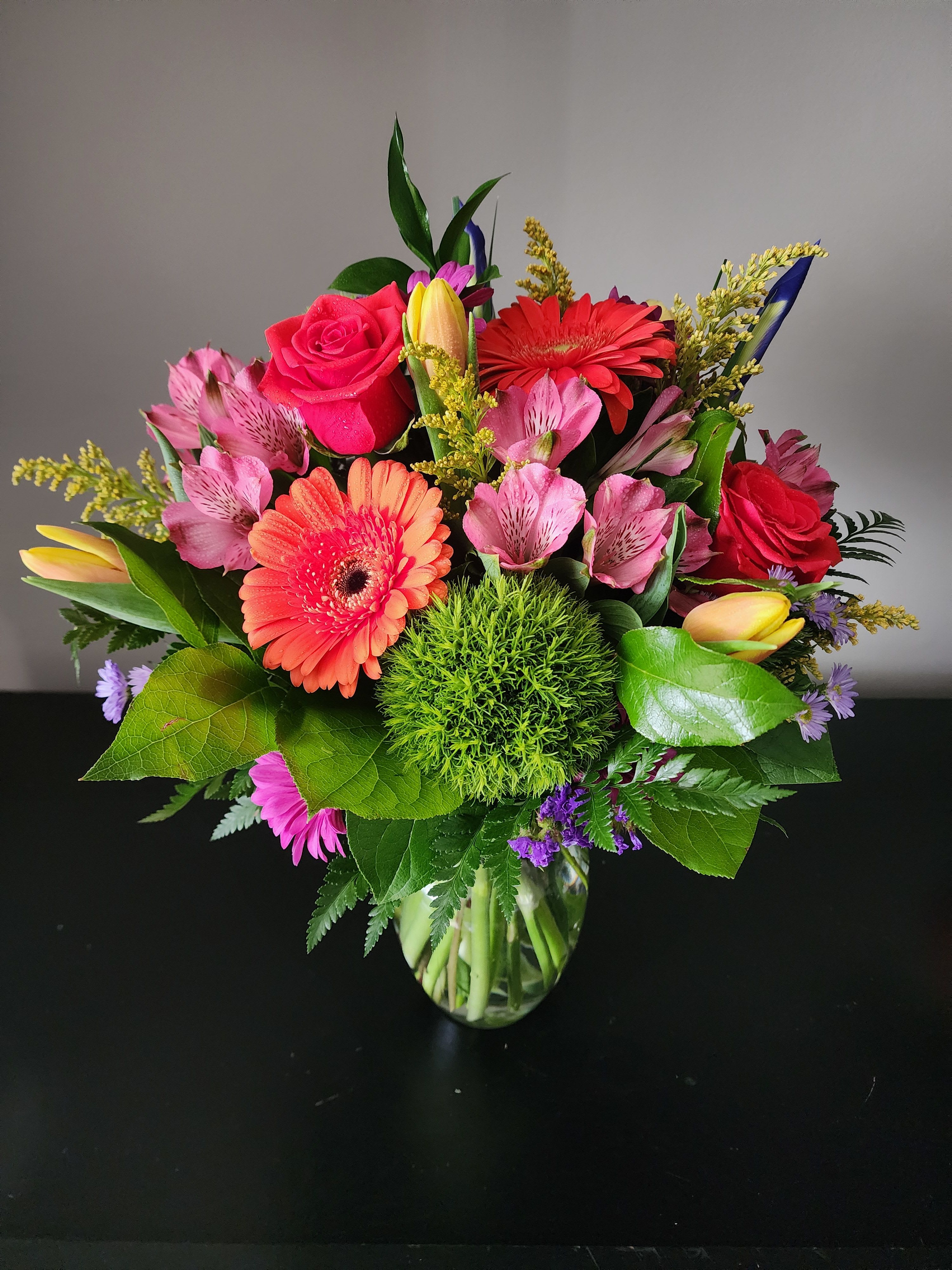 Mixed bouquet of pink and red flowers in a glass vase