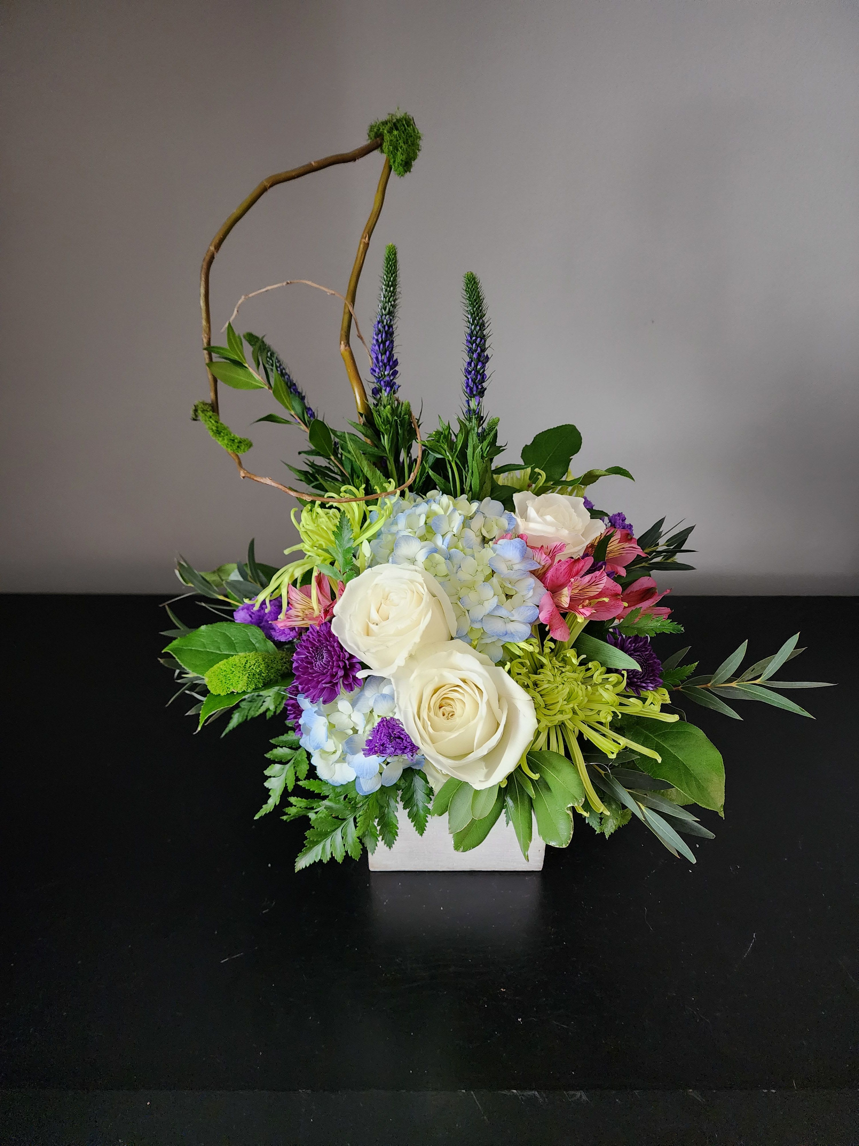 Emerald Isles  - This fresh trendy arrangement is designed in a wooden cube with fugi mums, alstroemeria,  roses, hydrangea and fun greenery.