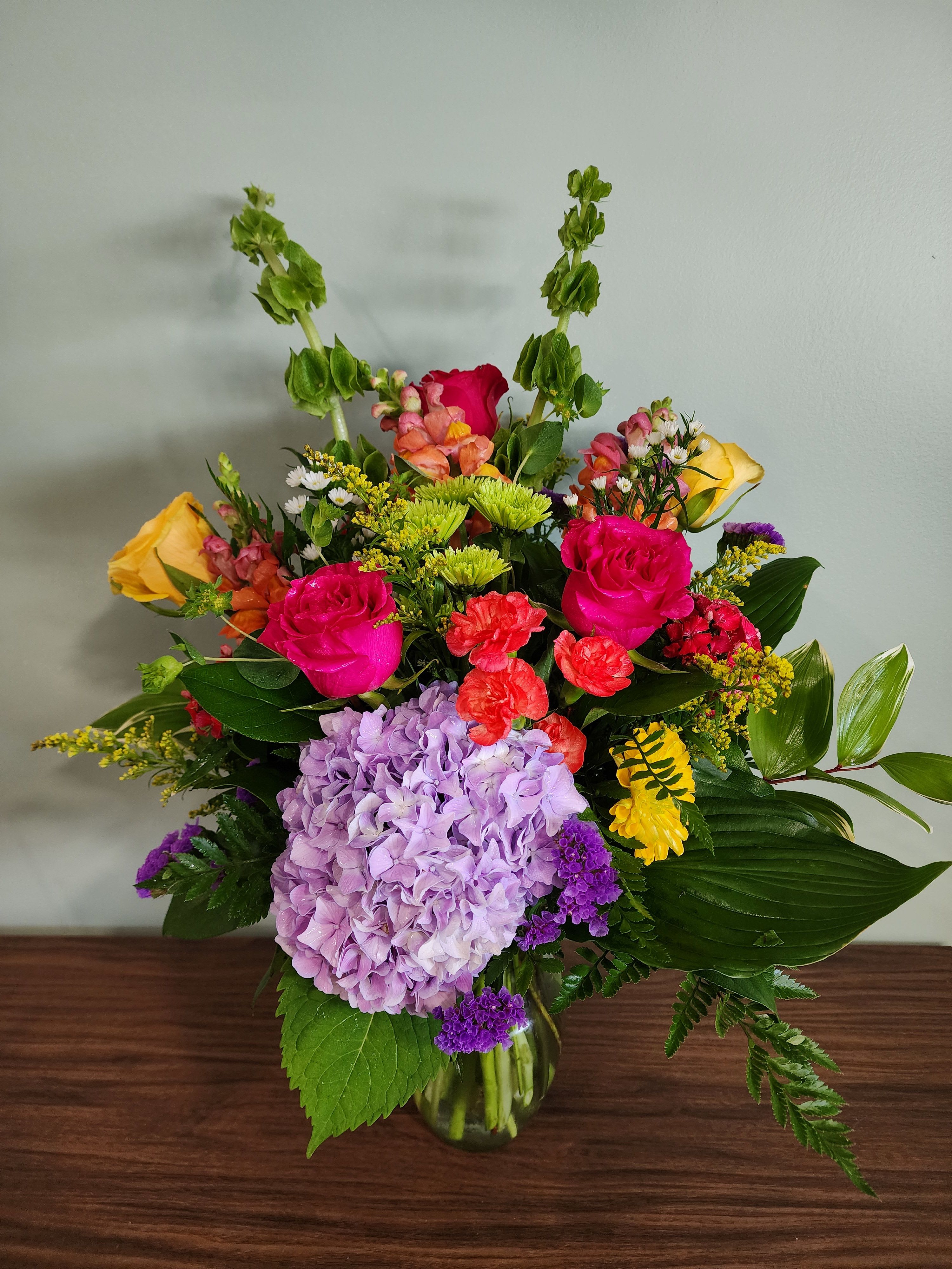 Mixed bouquet in a glass vase with pink roses and lavender hydrangea