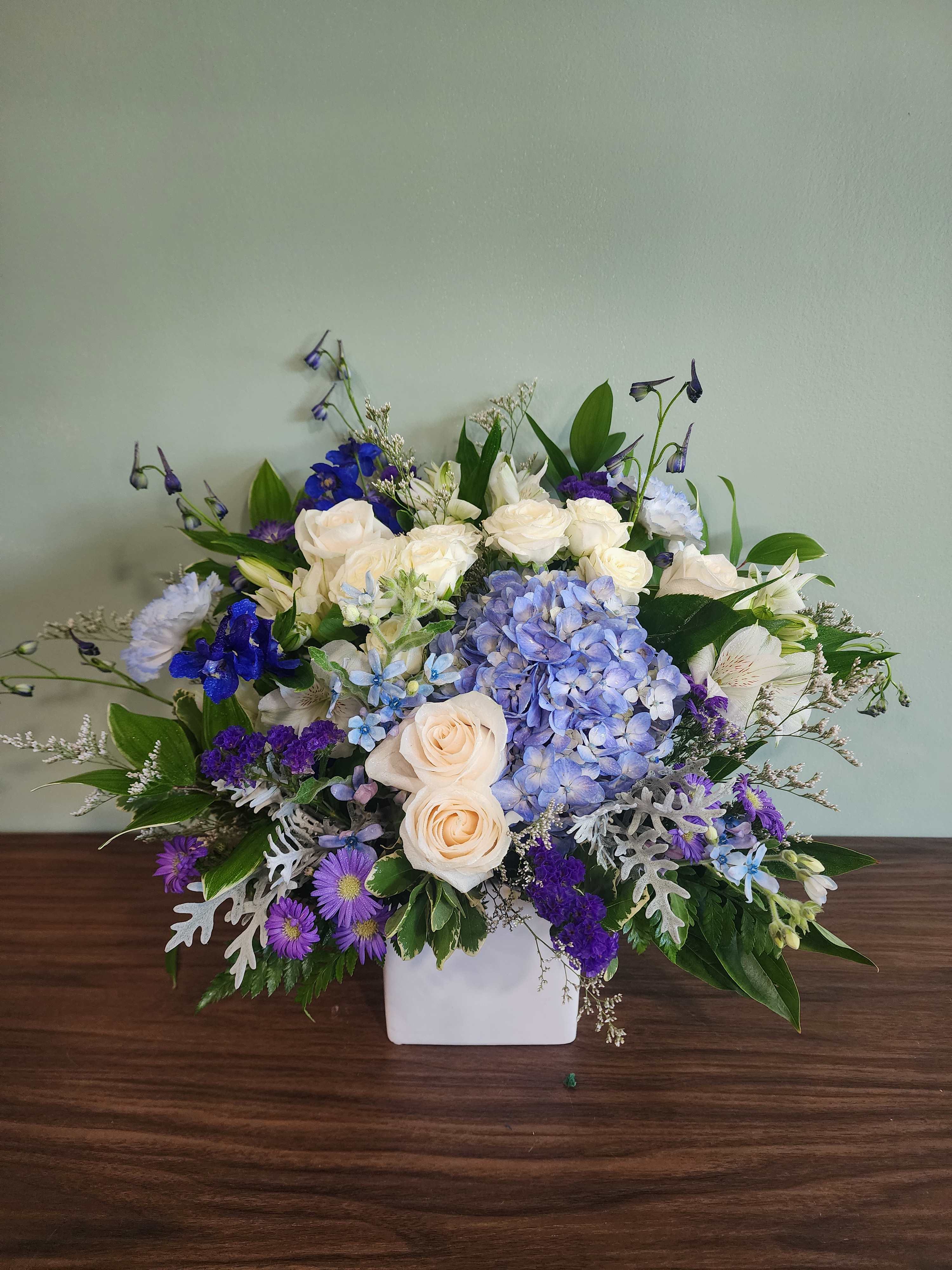 Blue and white floral arrangement in a white vase