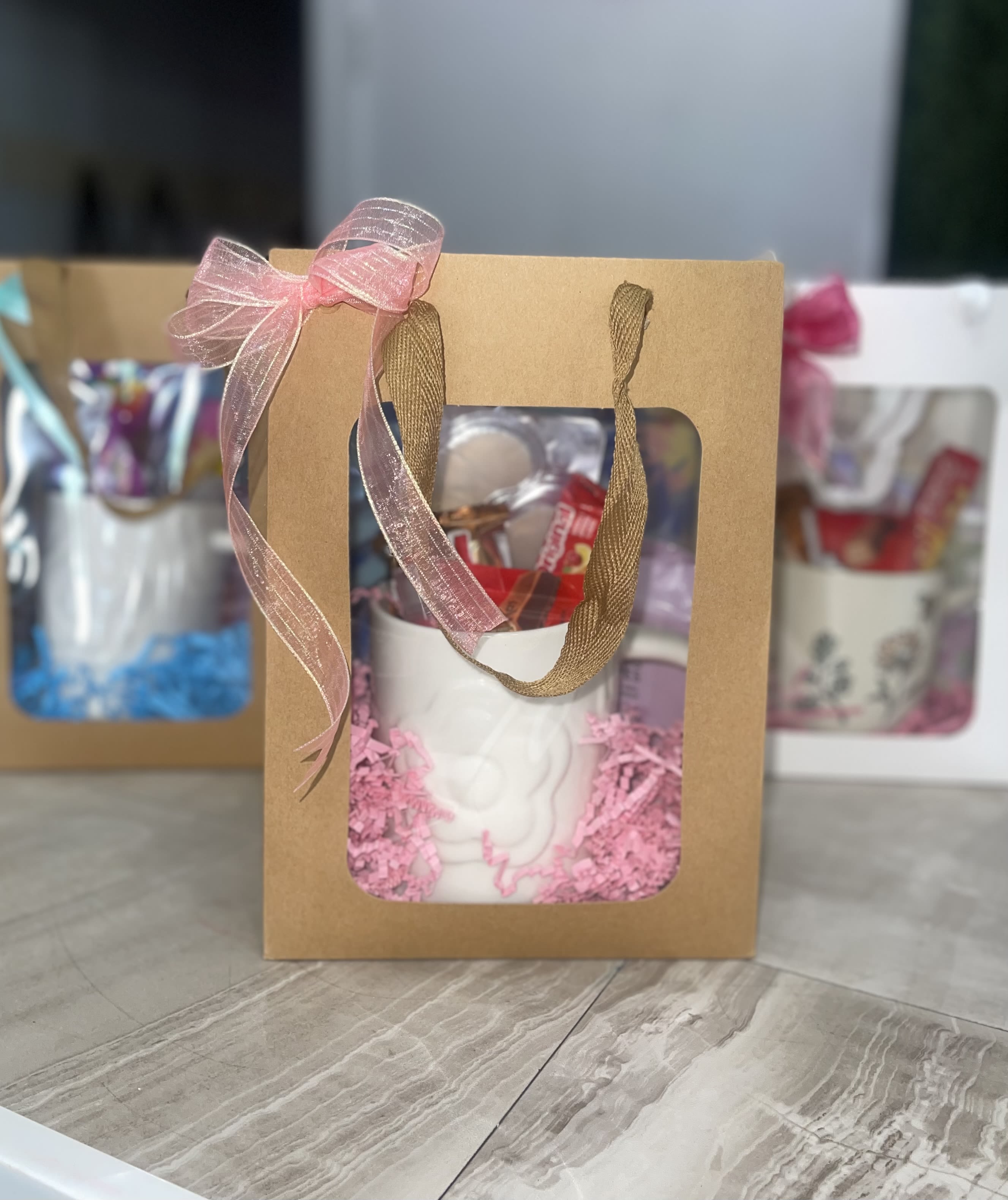 A Little Pick Me Up Gift Bag or Mug Gift -  Make them smile with a thoughtfully curated gift. Surprise them  with a charming gift bag featuring a beautiful mug for a selection of sweets, from delicious options like Starburst, Skittles, Hershey’s, KitKat, Snickers, or Three Musketeers (Leave which three you'd like in notes if none is left we’ll hand-select the perfect combination) Eye Patches, face masks, a cute hand pouch and a small teddy bear. Please note: mug designs may vary based on availability, but each one is thoughtfully selected to be just as special. All in one perfectly packaged gift—simple, sweet, and made to pick them up!  