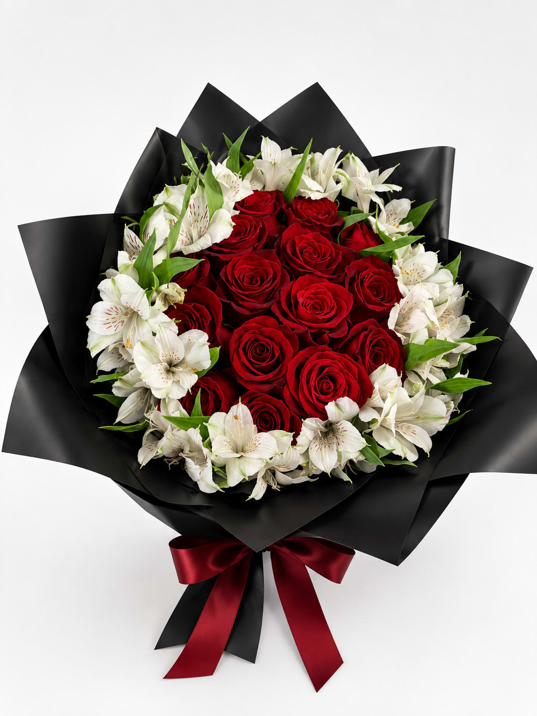 Red roses and white alstroemeria in black wrap with a red ribbon