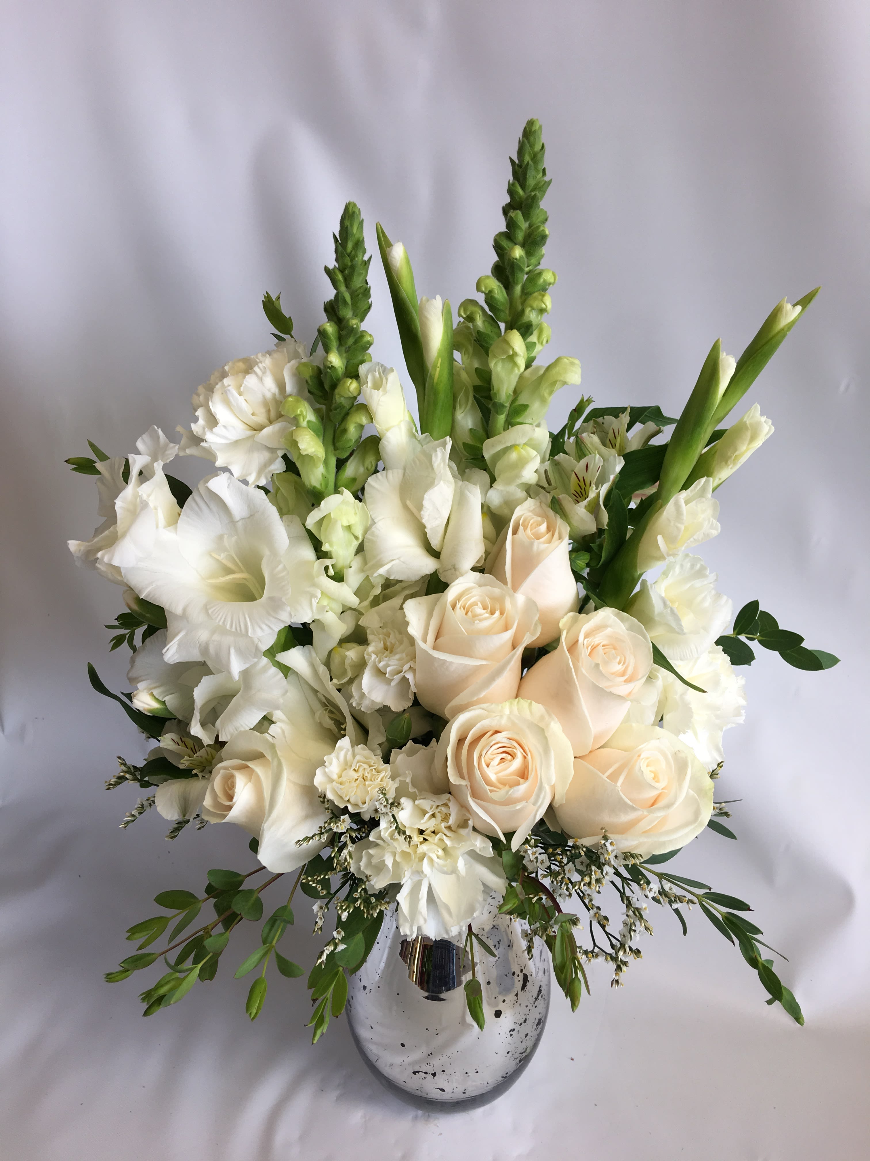 White and cream floral arrangement in a silver vase