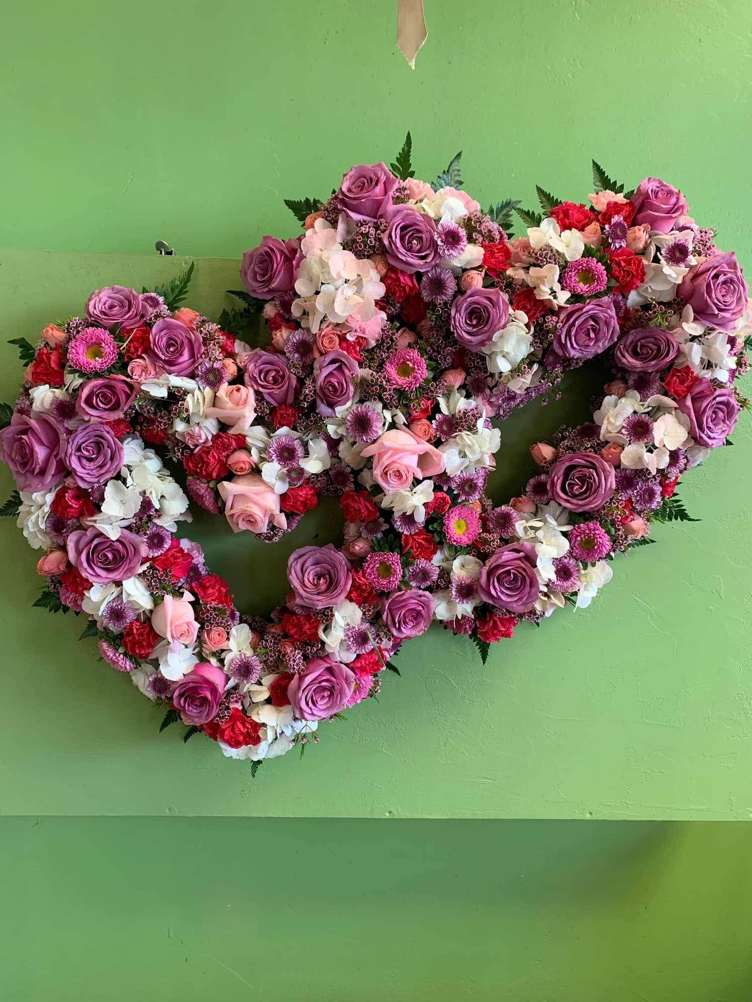 Heart-shaped floral wreath with purple roses and pink-white blooms