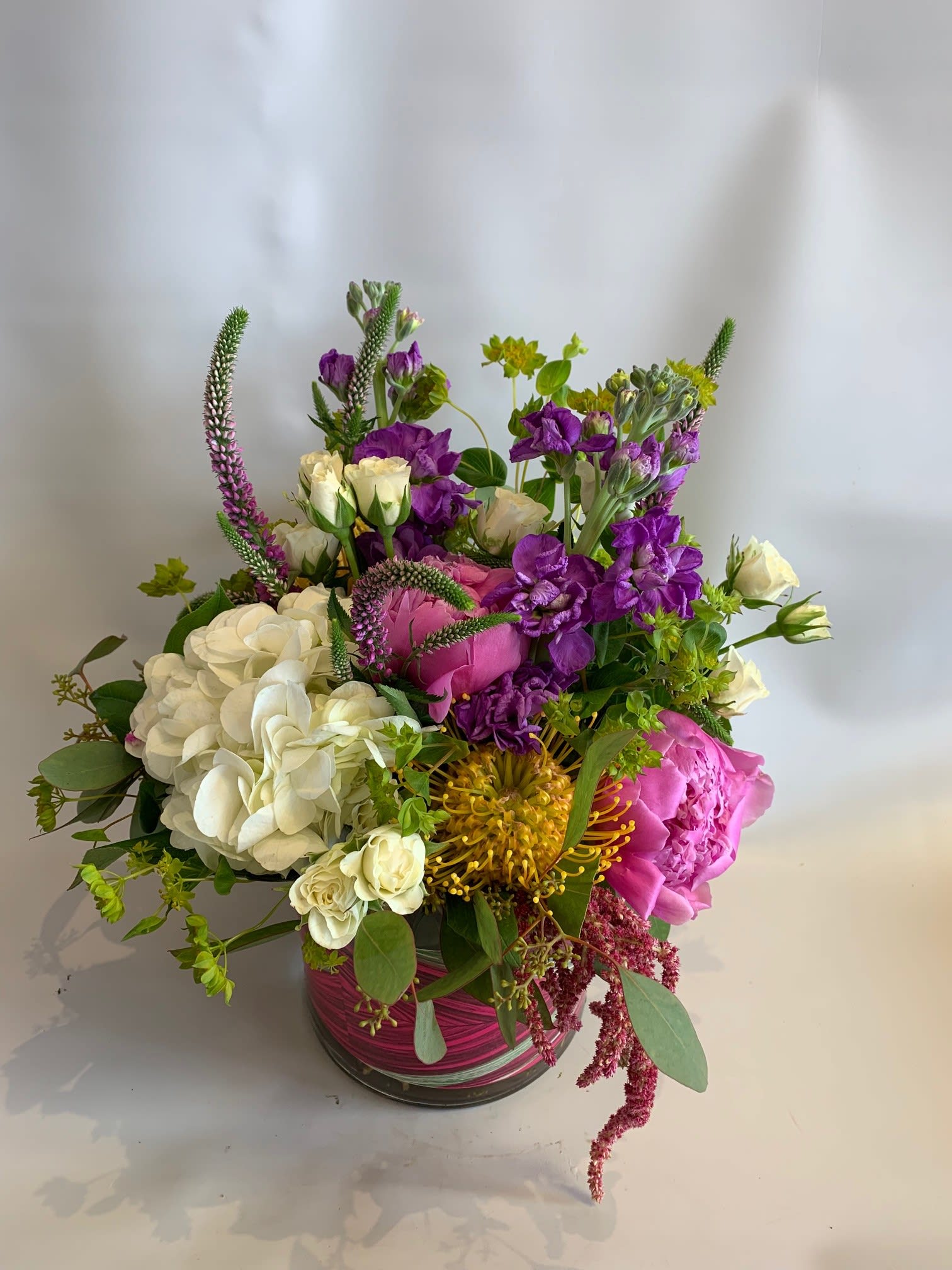 Mixed bouquet in a glass vase with white, pink, and purple flowers