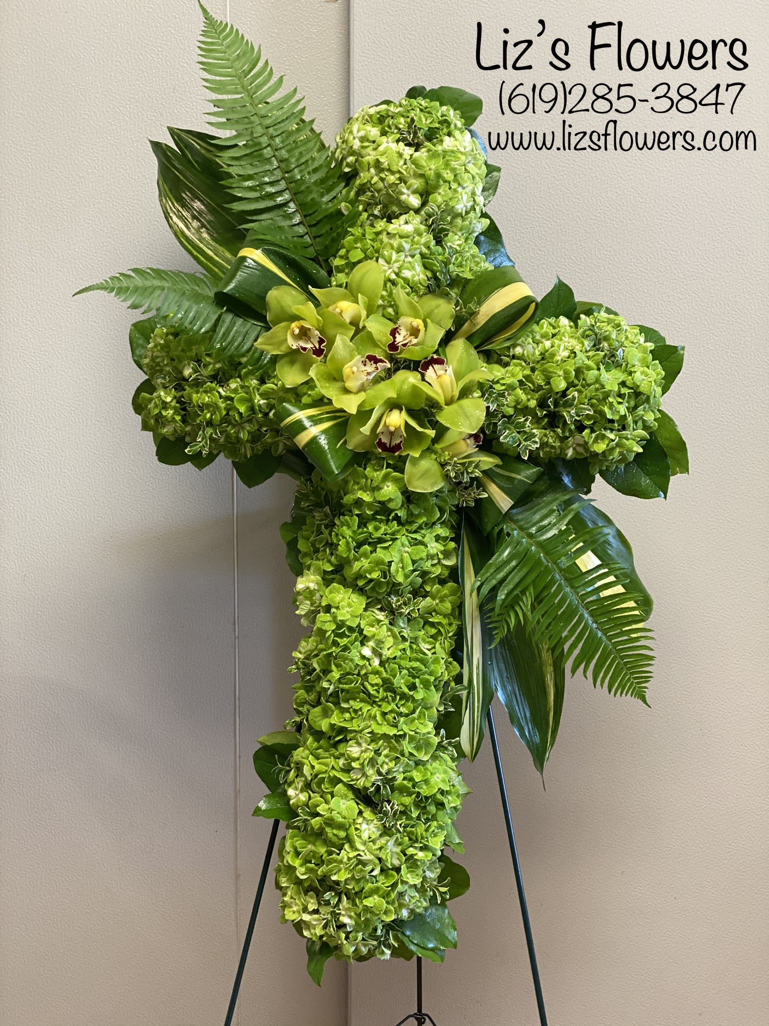 Green floral standing cross with orchids and hydrangeas
