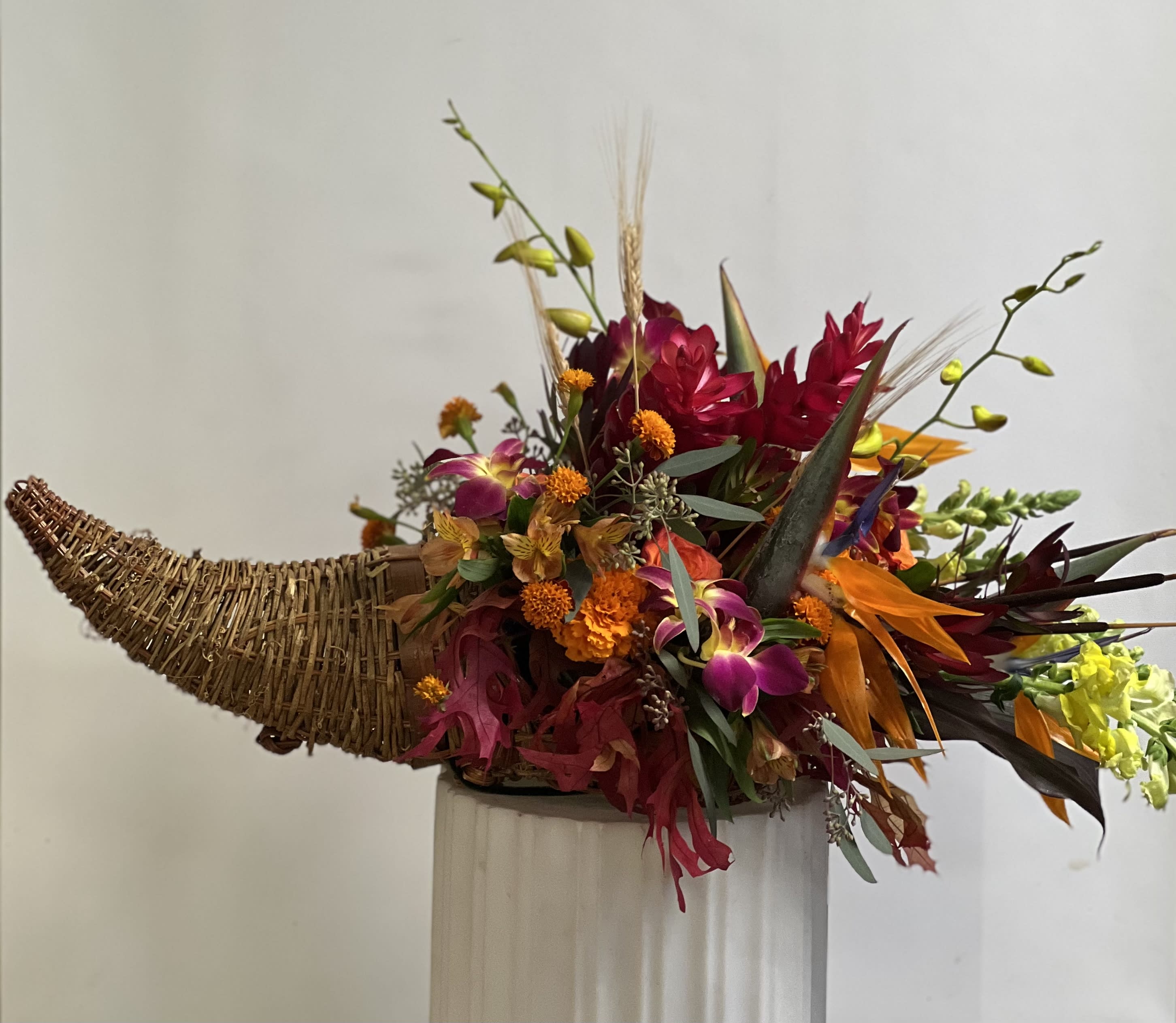 Tropical floral arrangement in a woven horn-shaped container