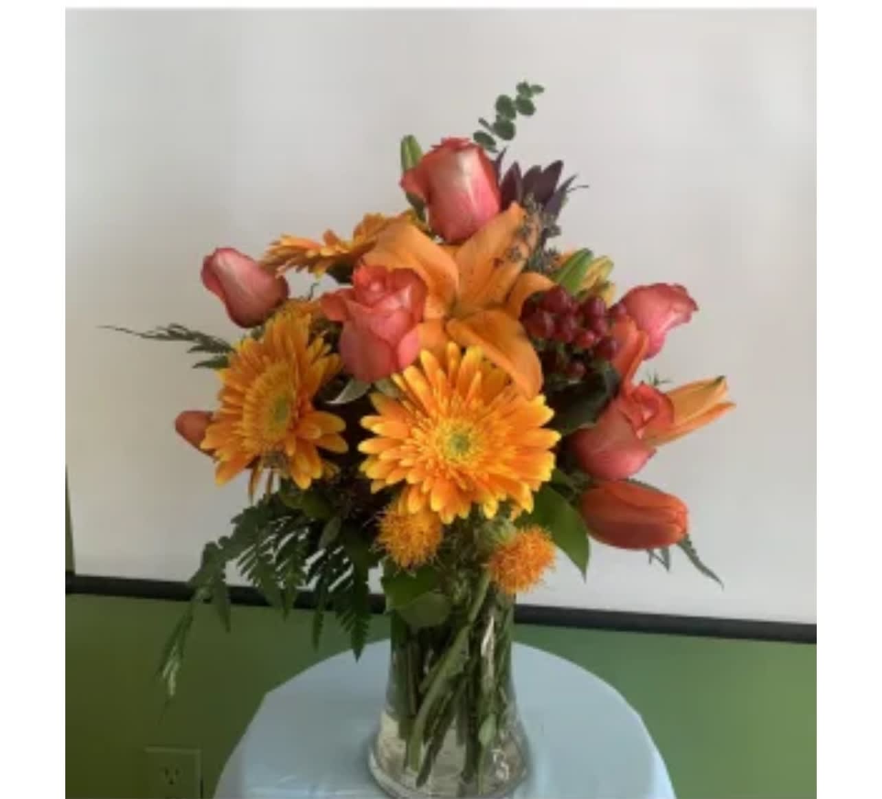 Orange and pink mixed bouquet in a clear glass vase