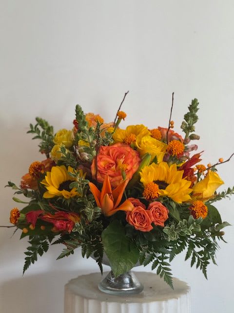 Orange and yellow mixed flower arrangement in a silver vase