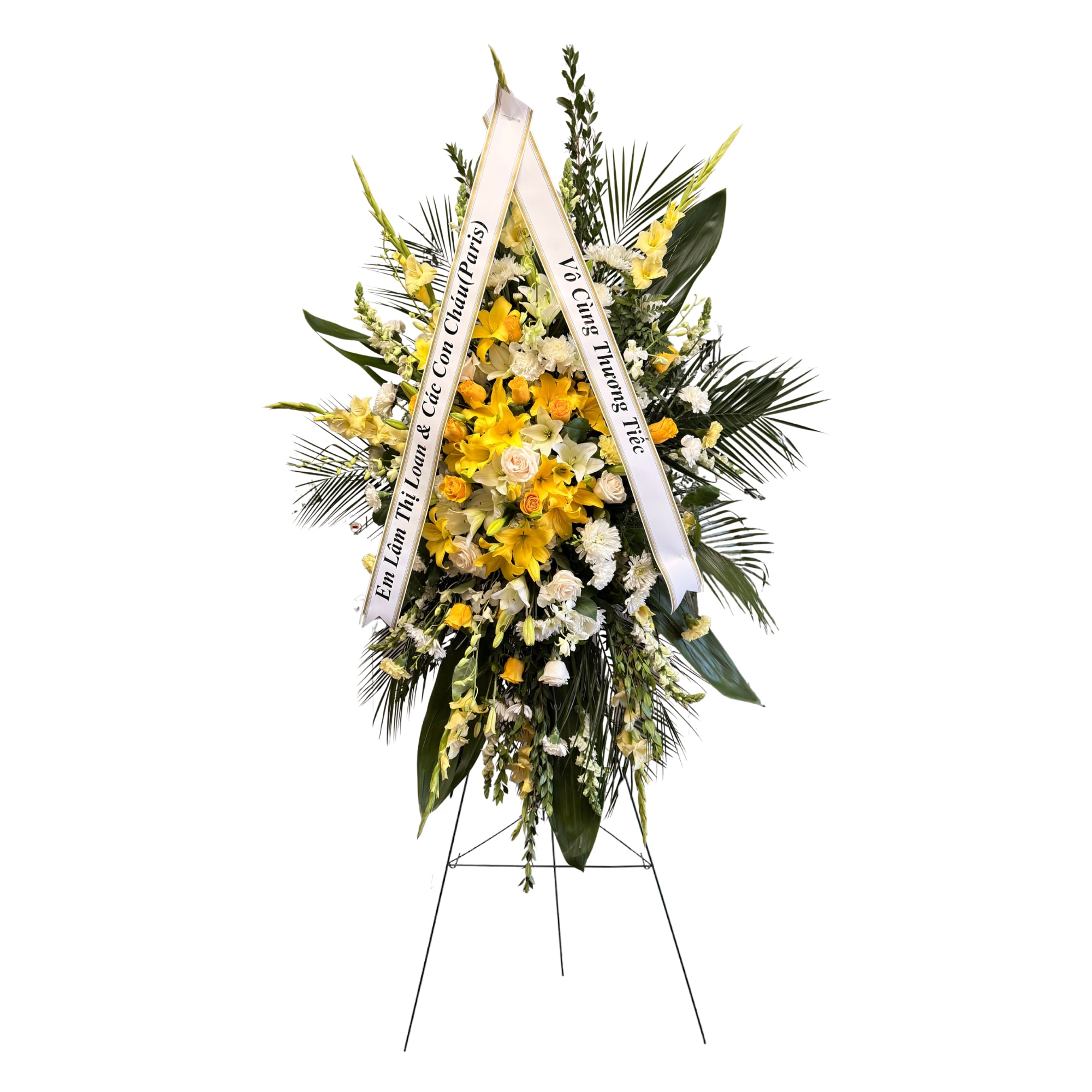 Golden Tribute Standing Spray - Lush tropical greenery and tropical yellow blooms. 