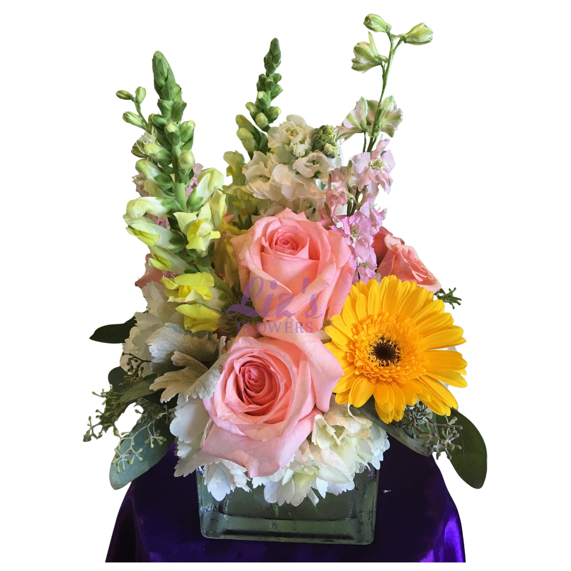 Spring in cube - A group of hydrageas, roses, snapdragons, larkspurs, stocks and gerberas in a clear cube. 10"Hx8"W