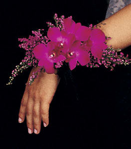 Pink orchid wrist corsage on a person's wrist