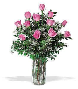 Pink roses arranged in a tall clear glass vase