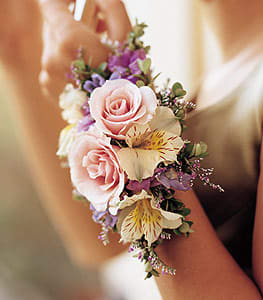 Pink rose wrist corsage with small purple and cream flowers
