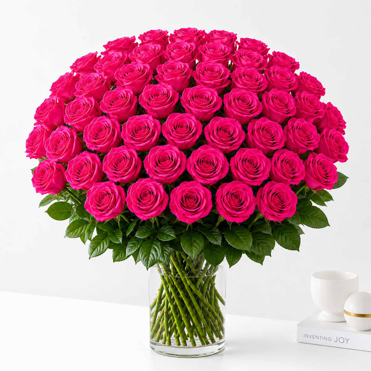 48 Hot Pink Roses  - Elegant, and timeless, this bouquet of premium hot pink roses is beautifully arranged in a clear glass vase with lush greenery. A graceful expression of admiration, gratitude, and affection, it's the perfect gift for birthdays, anniversaries, congratulations, or simply to brighten someone's day.