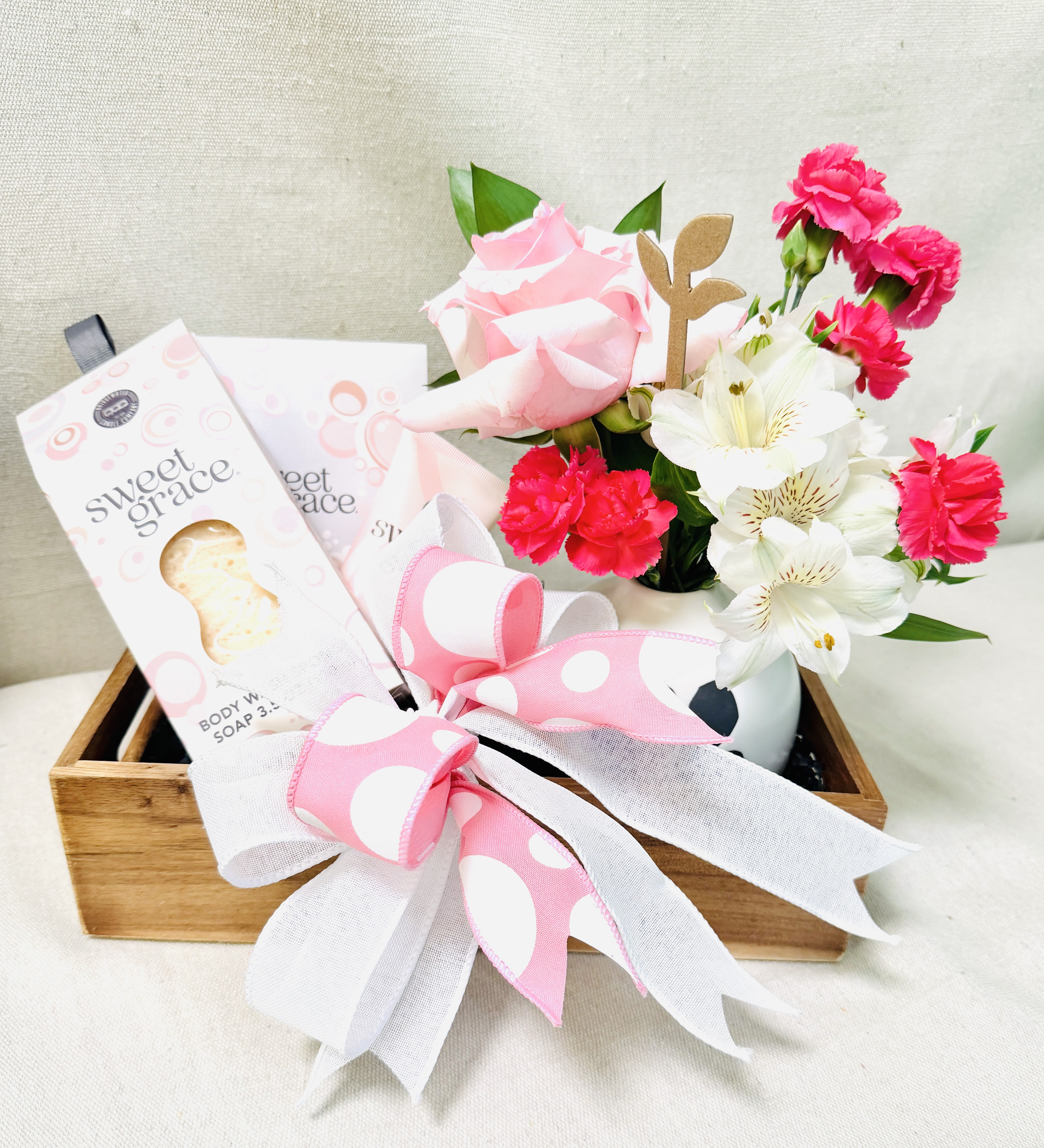 Pretty Pampered - When you really want to pamper the one you love!  This gift box has a floral arrangement in a beautiful black and white vase.  Pair beautiful florals with some luxurious, fragrant spa items she will reach for again and again. She will feel OH SO SPOILED!  Included is a floral, Sweet Grace hand lotion, sachet, and body wash sponge. All contained in a wooden box with a bow to make her feel special.   