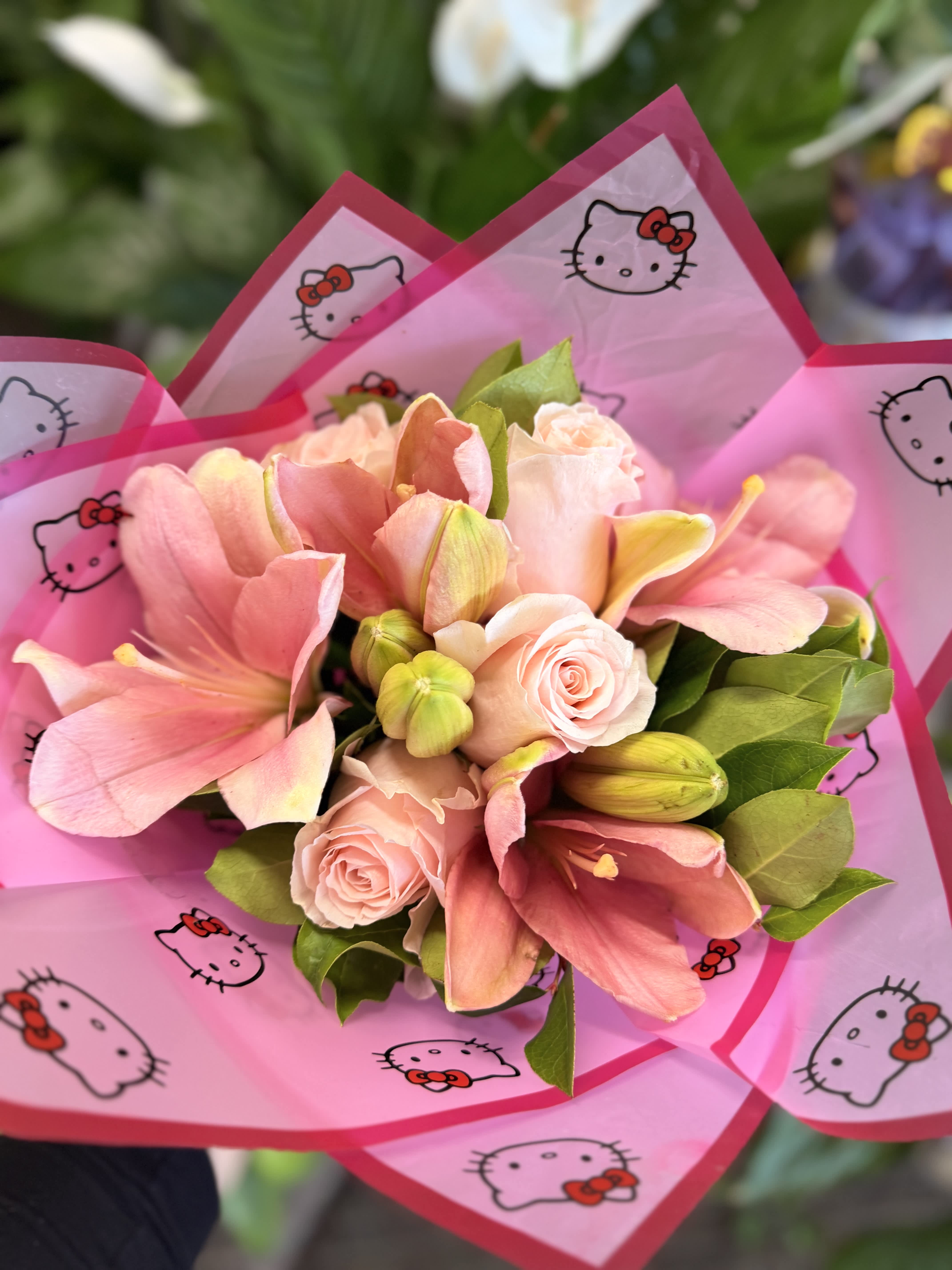Pink bouquet with roses and lilies wrapped in Hello Kitty paper