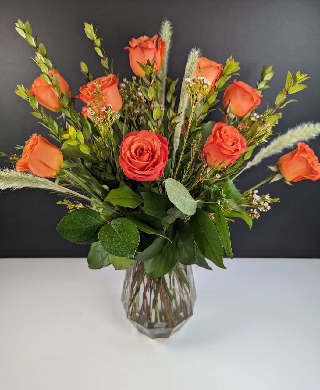 Orange roses arranged in a clear glass vase