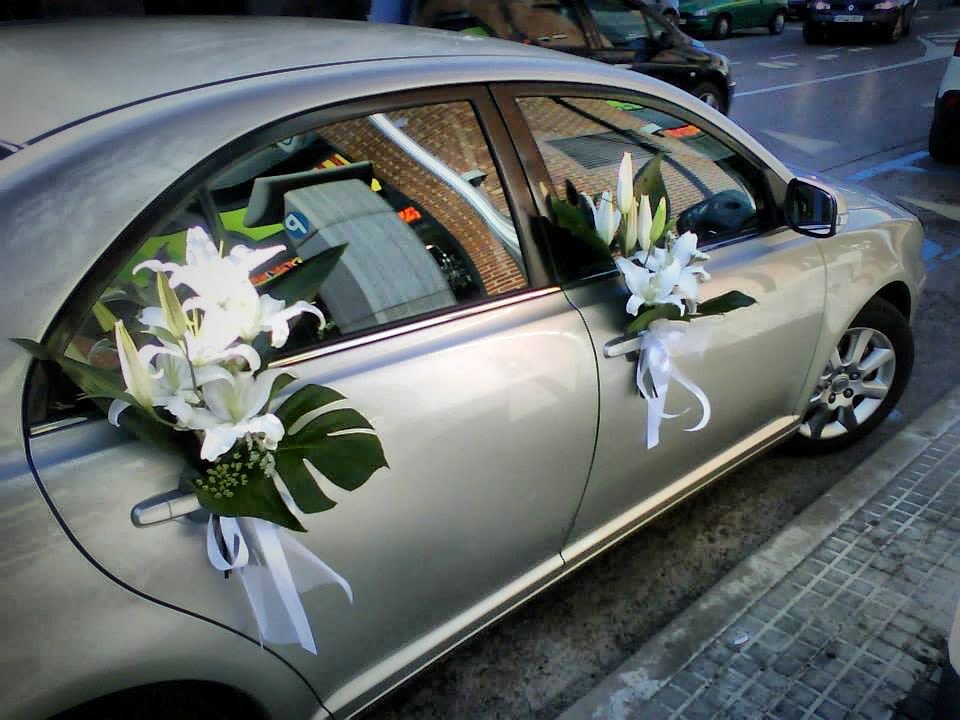White lilies with ribbons attached to a silver car