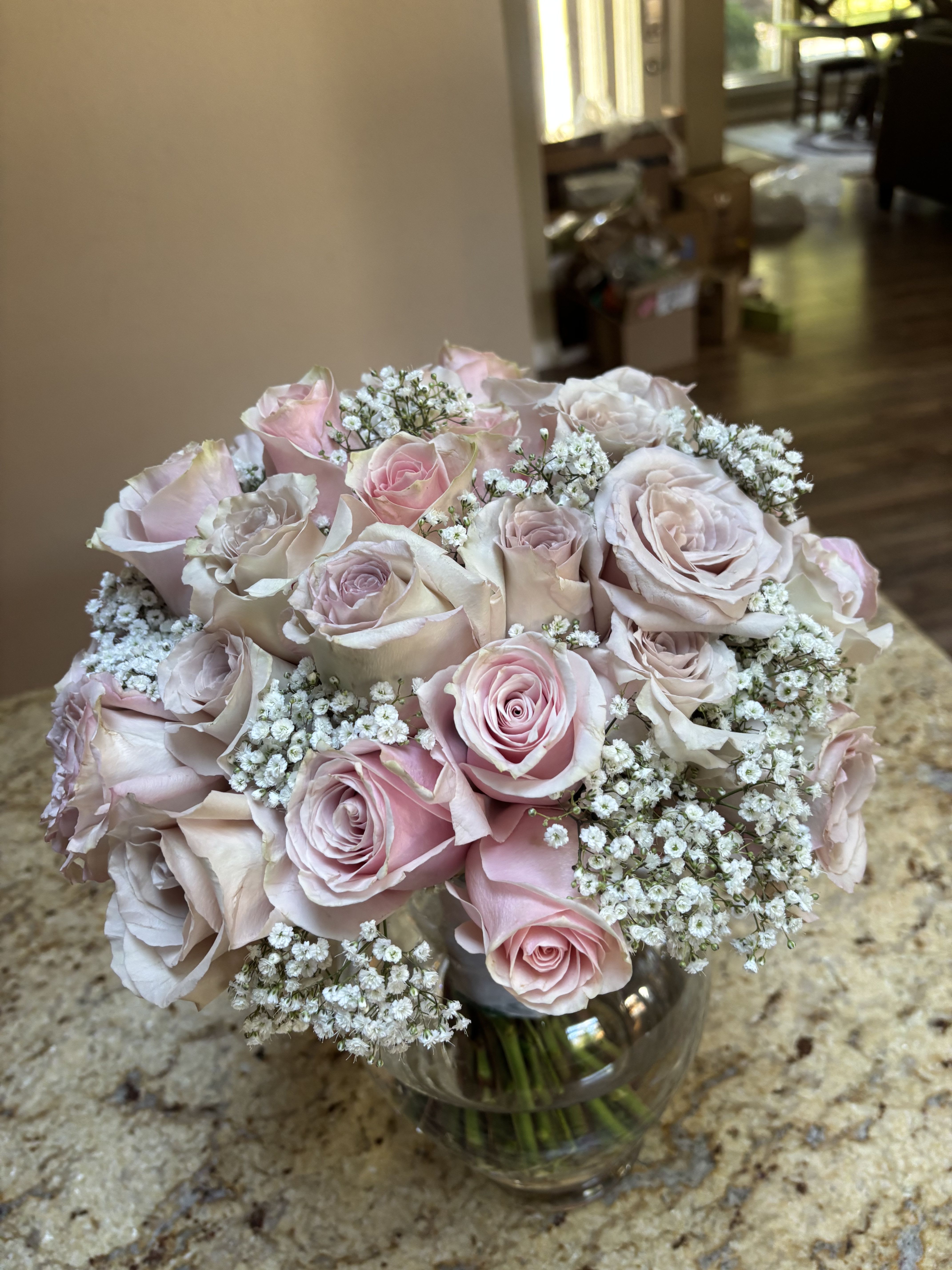 Bouquet of pale pink roses and baby's breath in a glass vase