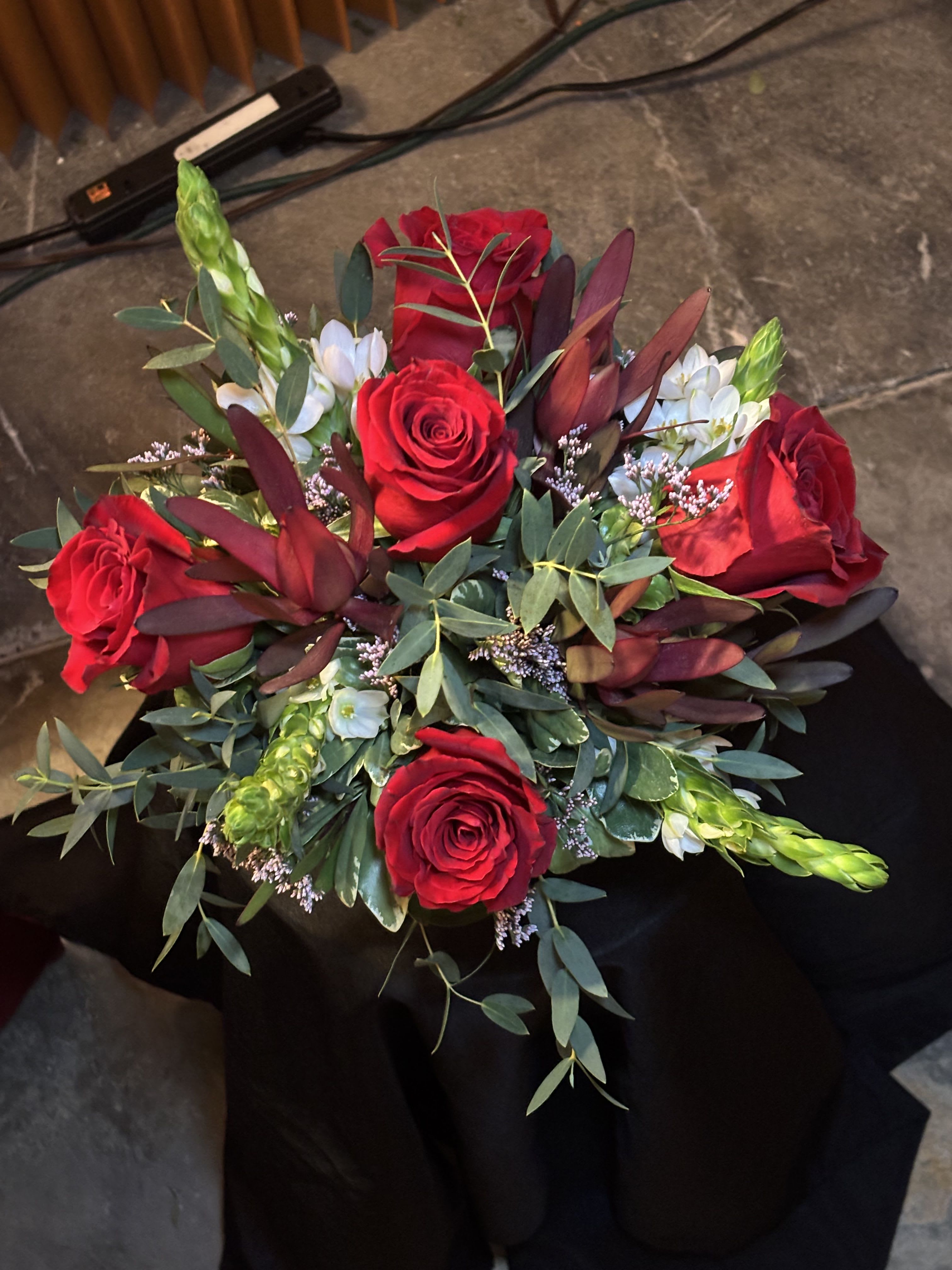 Bouquet of red roses with white accent flowers and greenery