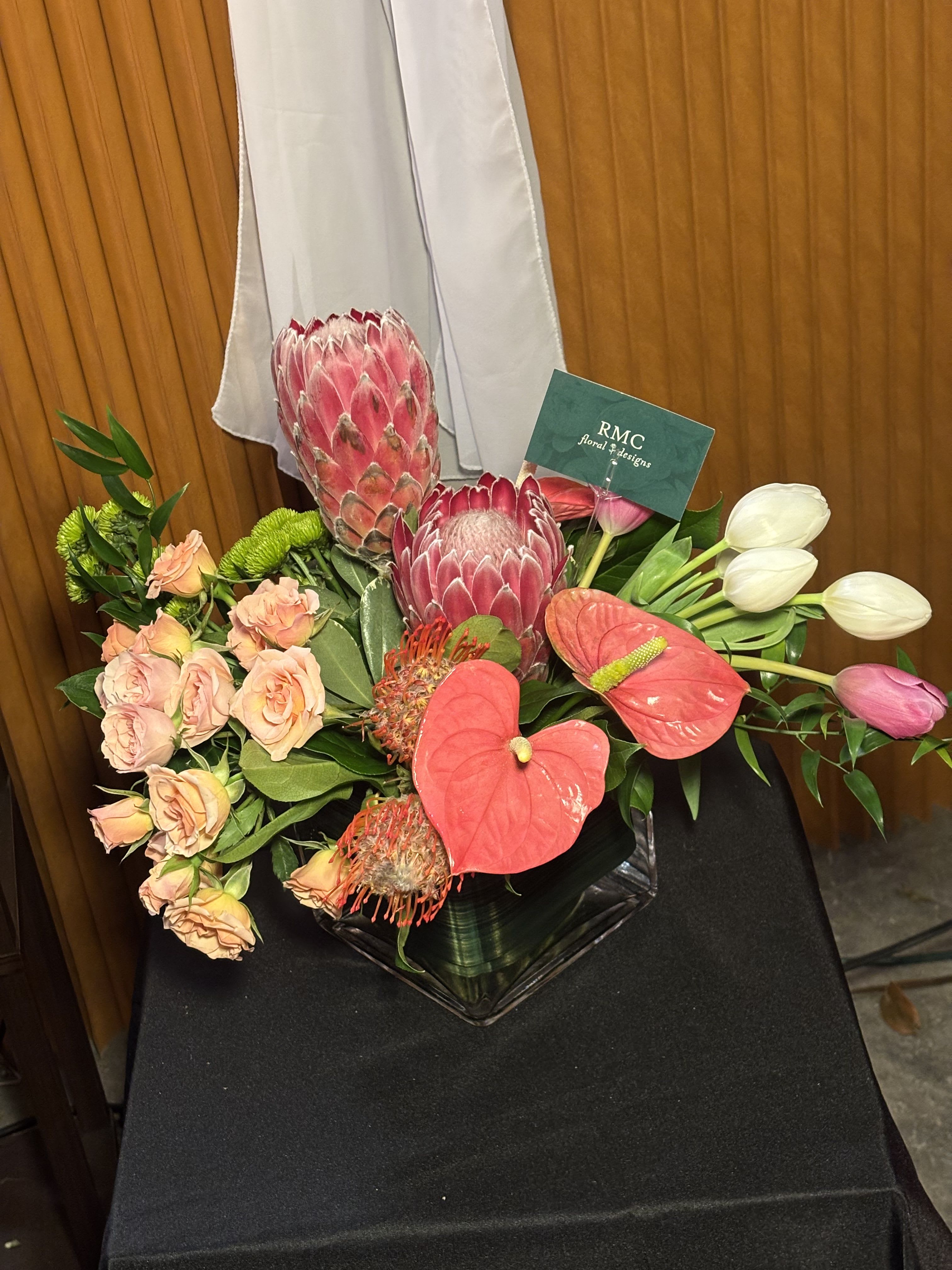 Golden Paradaise - Luxurious tropical floral arrangement featuring anthuriums, proteas, tulips, and mini roses, perfect for weddings, bridal bouquets, centerpieces, home decor, corporate events, and luxury gifts. Its exotic and elegant design makes it ideal for creating sophisticated and eye-catching floral arrangements.  Available for pickup at a downtown Seattle florist, crafted with high-quality, fresh flowers to ensure its beauty and longevity.