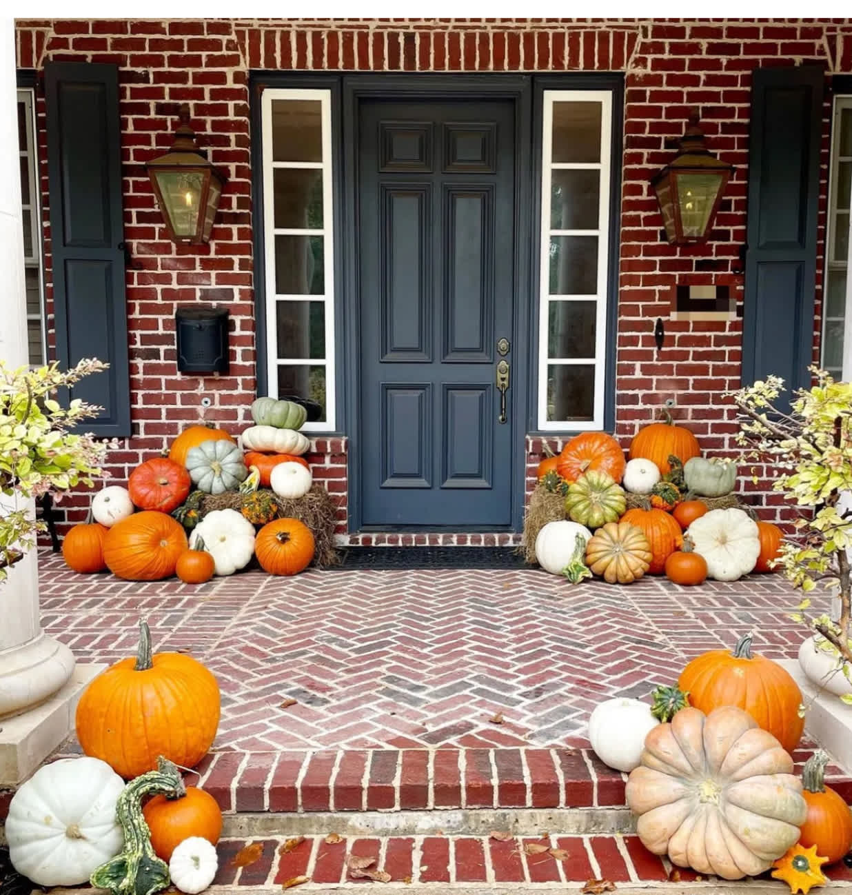 Front porch decorated with pumpkins and gourds around a blue door