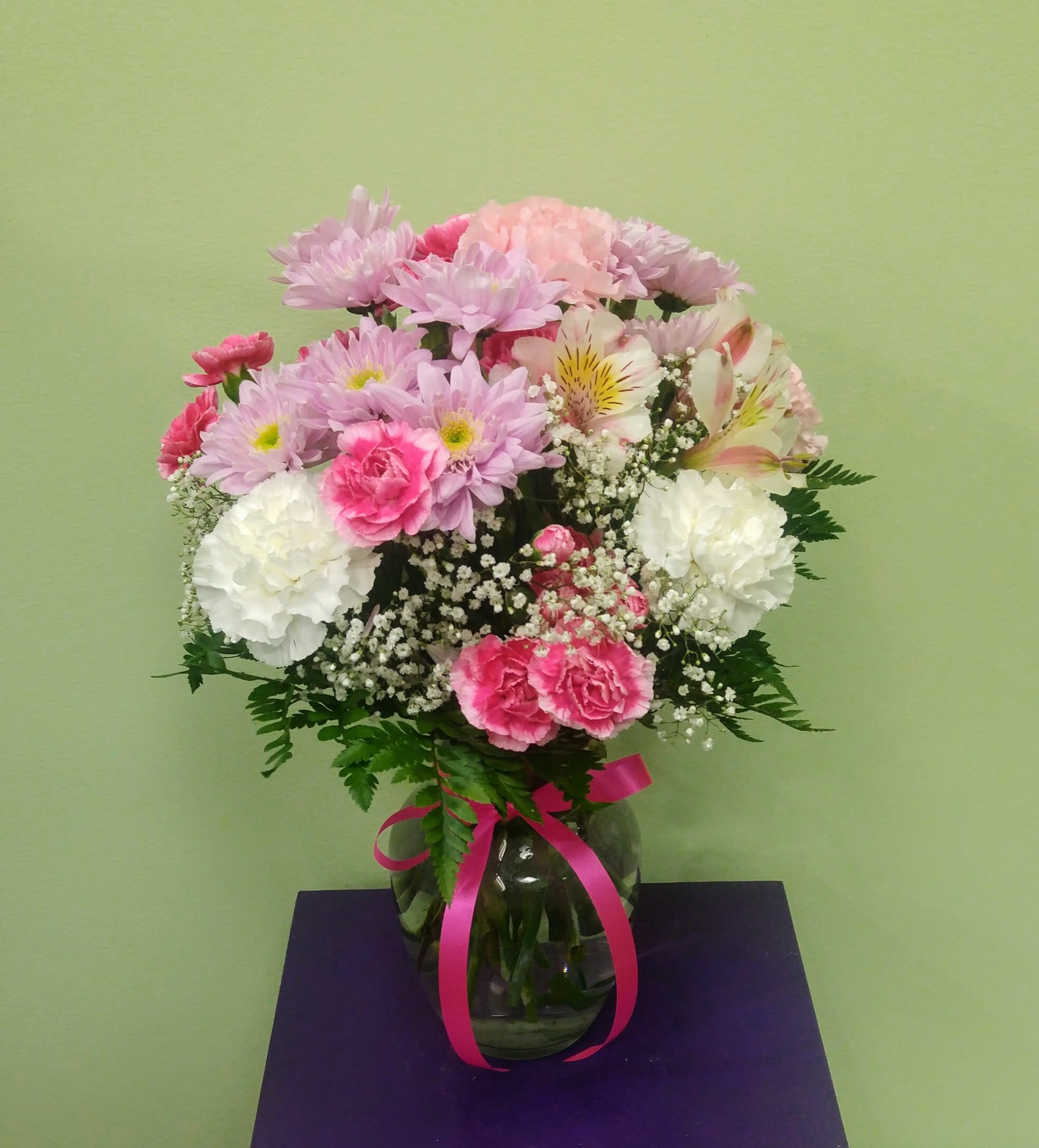 Pink and white mixed bouquet in a glass vase with a ribbon