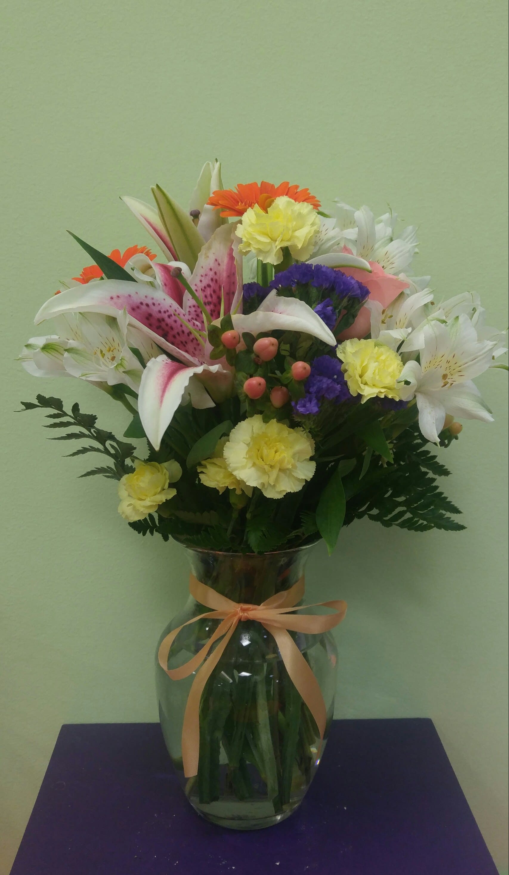 Mixed bouquet in a glass vase with lilies, carnations, and daisies