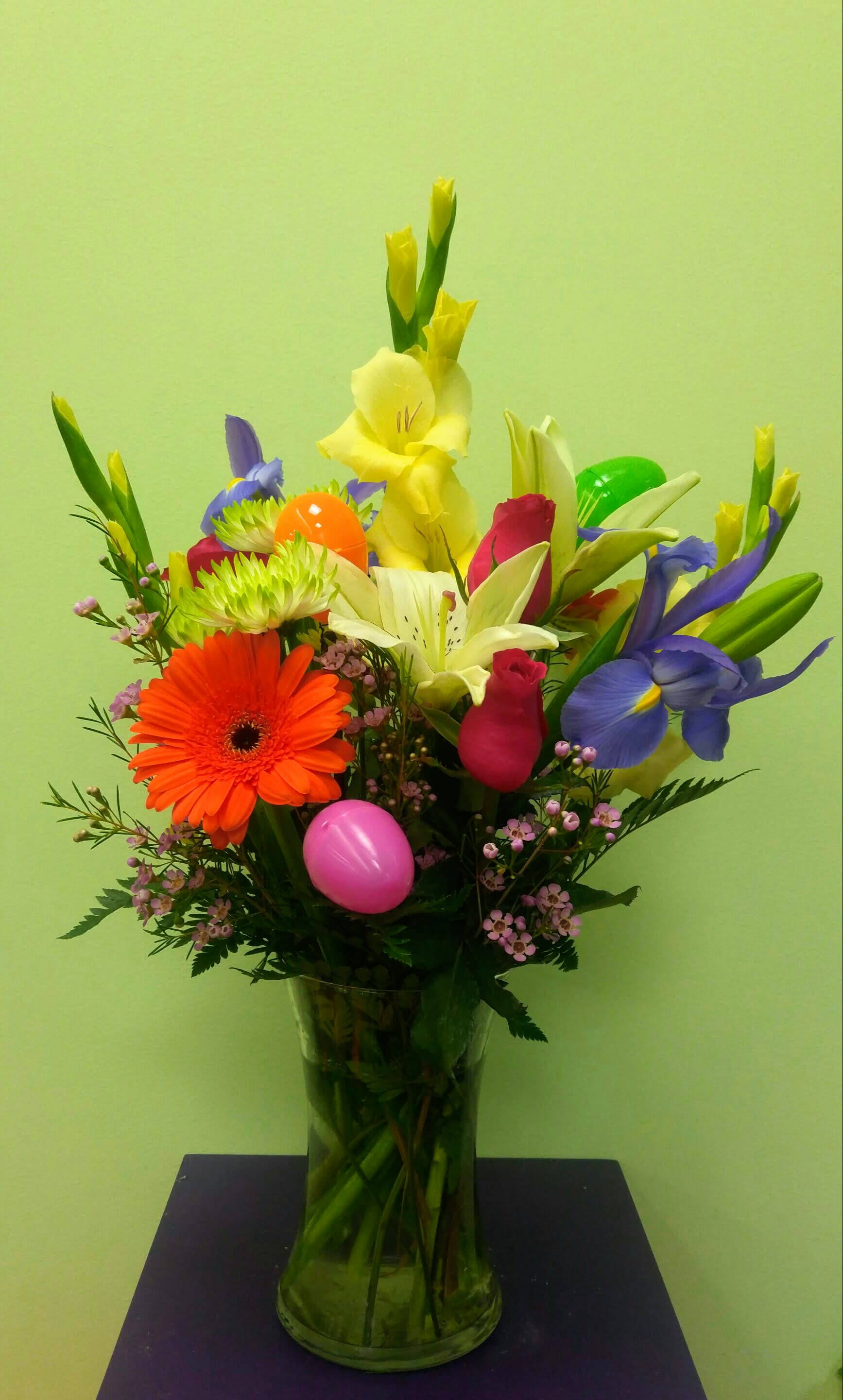 Colorful mixed bouquet in a clear glass vase with decorative eggs