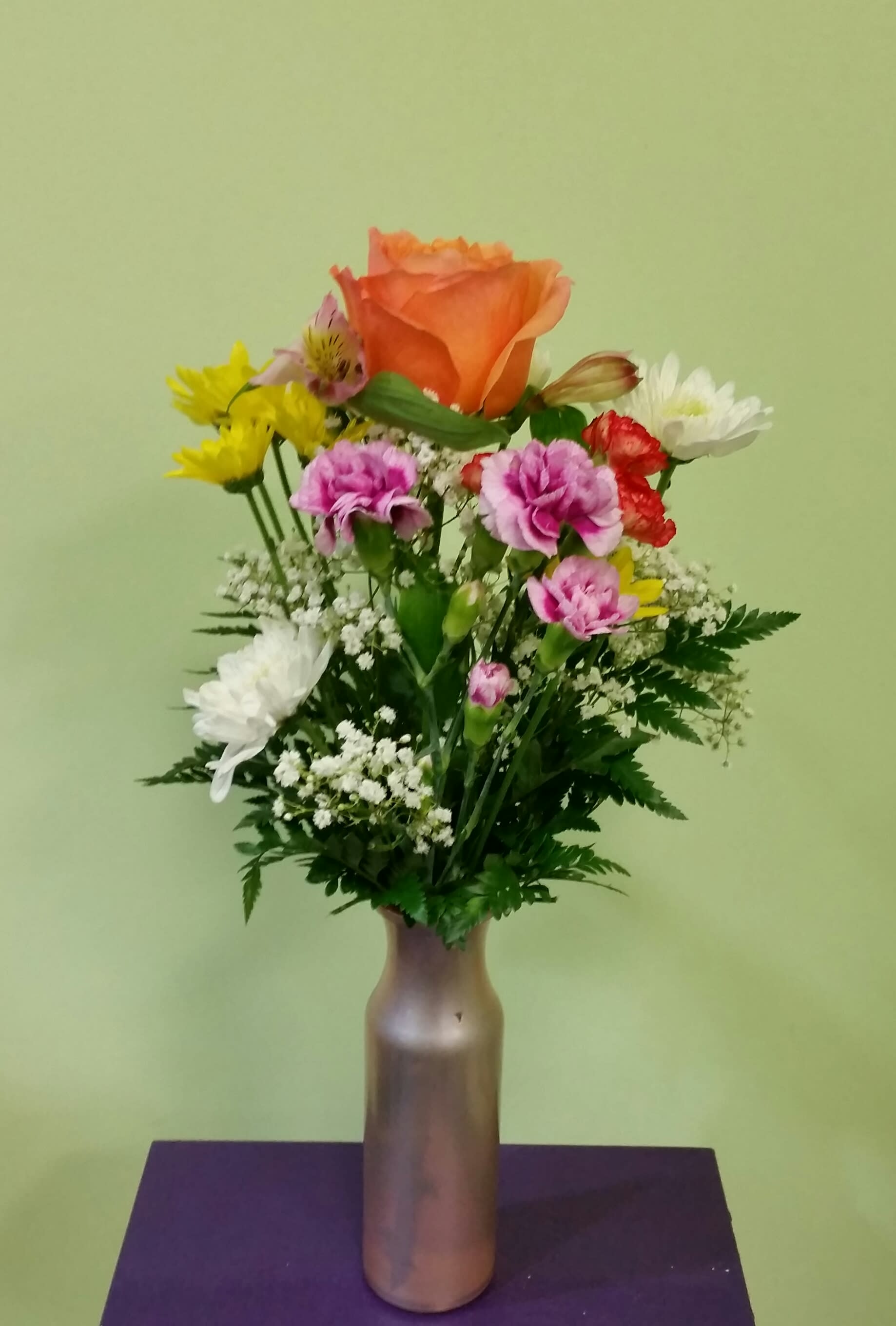 Buds of Spring - This design is a one of a kind bud vase that comes in a variety of pastel colors. A mixed arrangement is created by one of our professional designers. It is a beautiful spring arrangement that will make them smile!