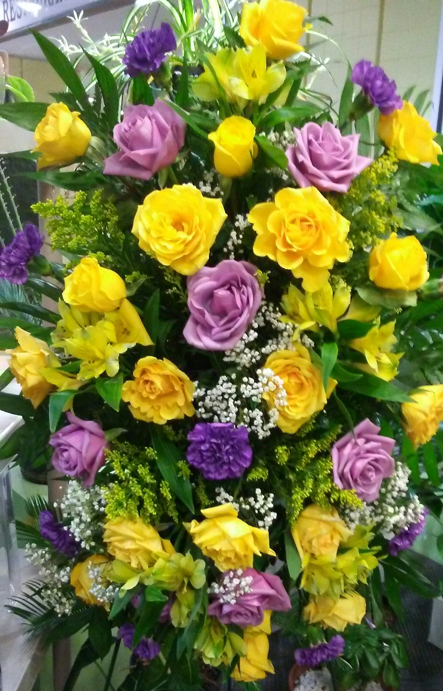 Tall bouquet of yellow and lavender roses with purple accents
