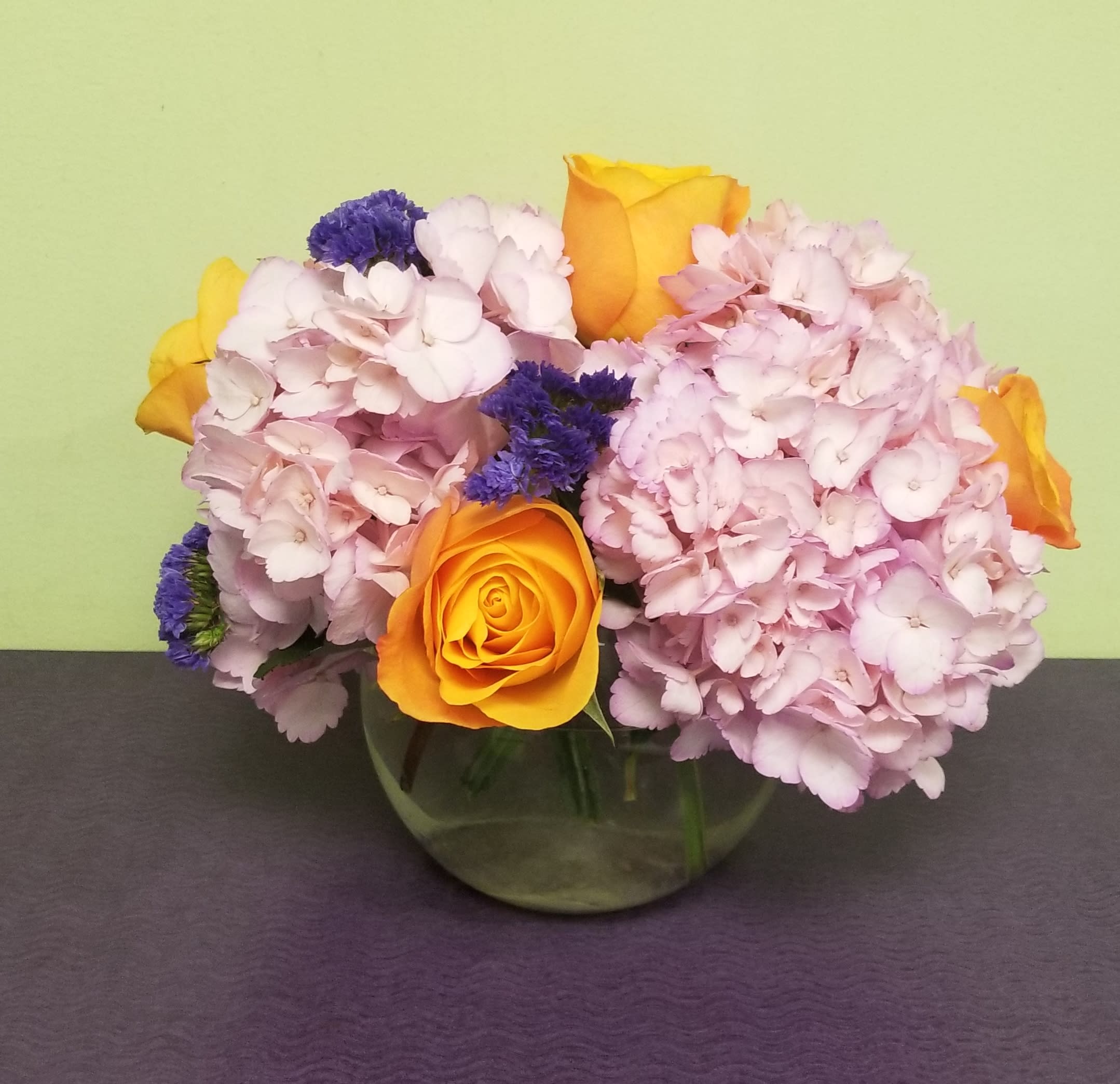 Pink hydrangeas with yellow roses in a glass vase
