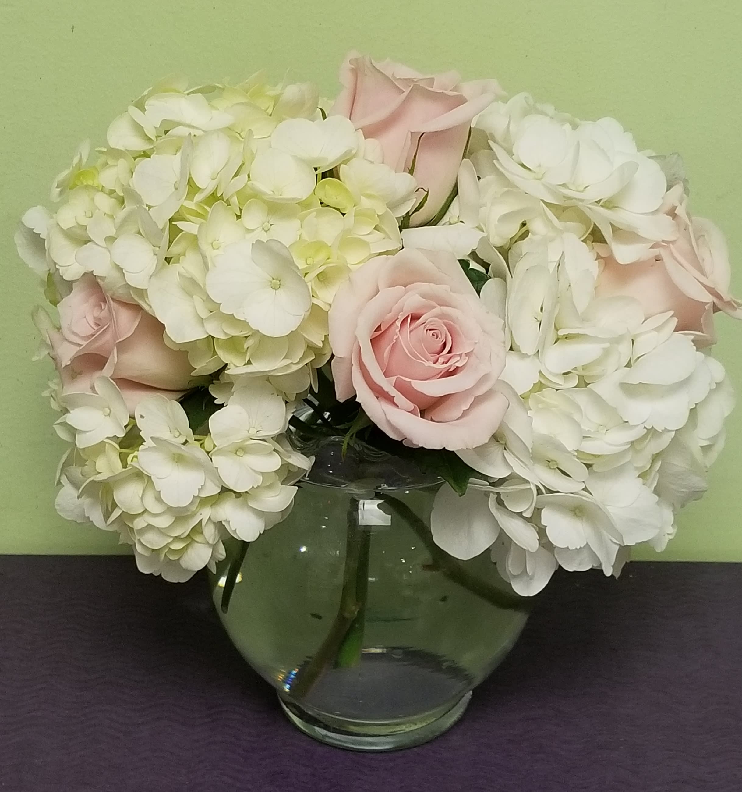 Pink roses and white hydrangeas in a clear glass vase