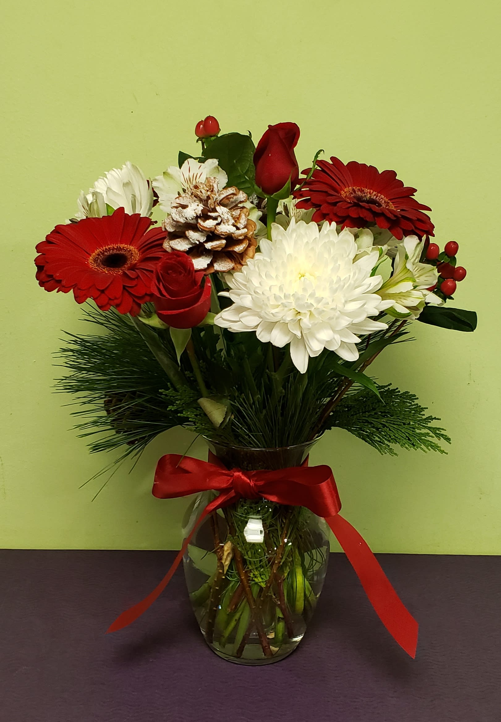 Red and white mixed bouquet in a glass vase with a red ribbon